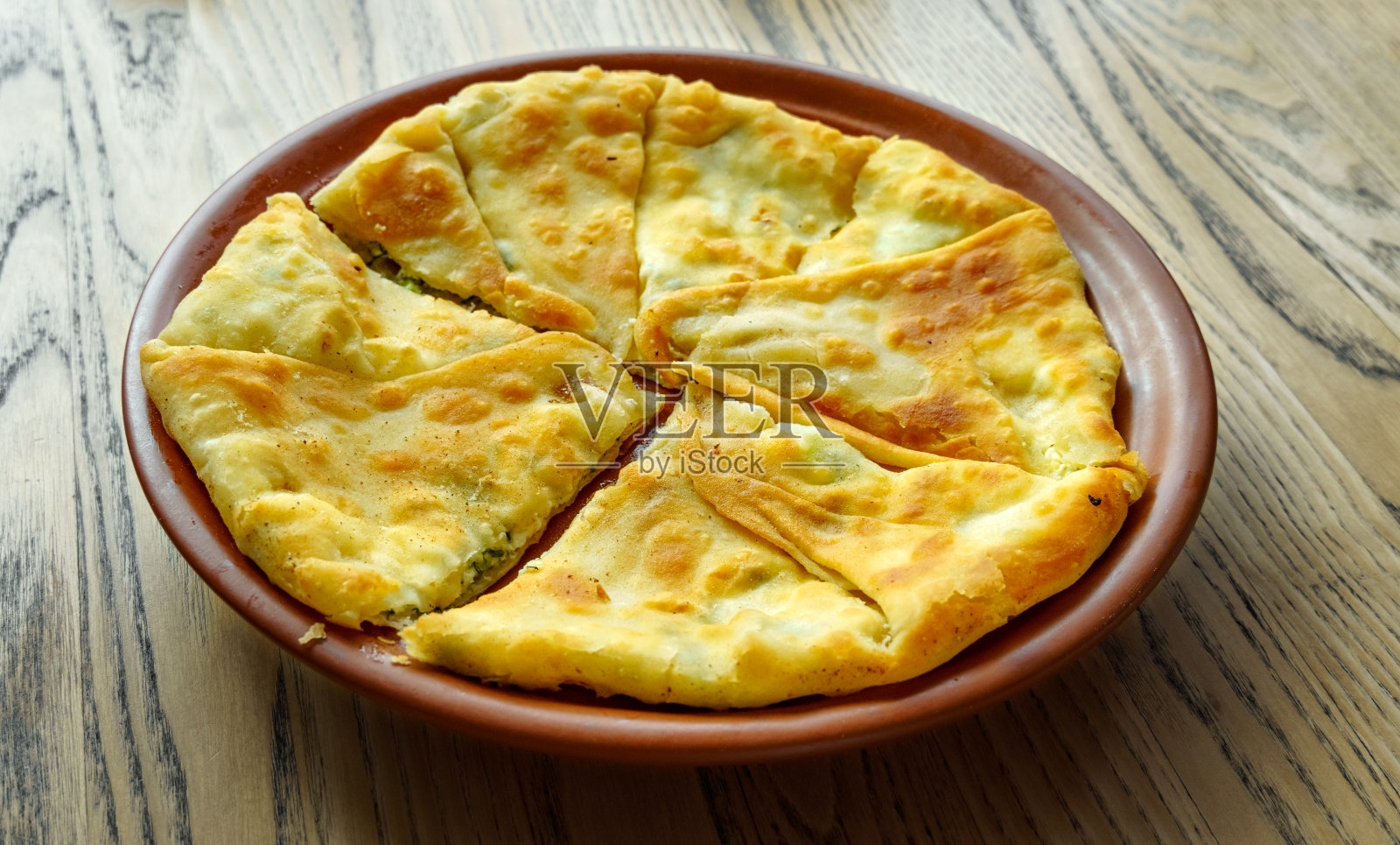 一张桌子放在木桌上。摩尔多瓦的面食包括各种油炸馅饼，馅料，松软干酪或土豆，卷心菜等。照片摄影图片