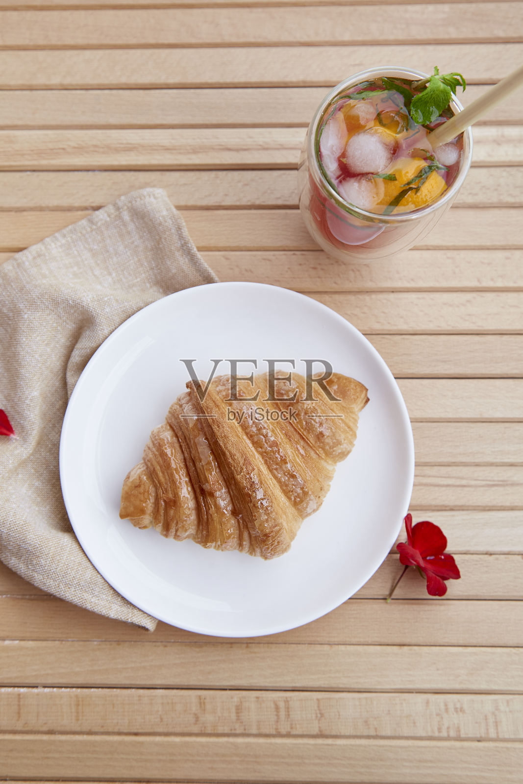 盘子上的法式面包皮和清爽的草莓莫吉托鸡尾酒在露台。早上的审美。俯视图照片摄影图片