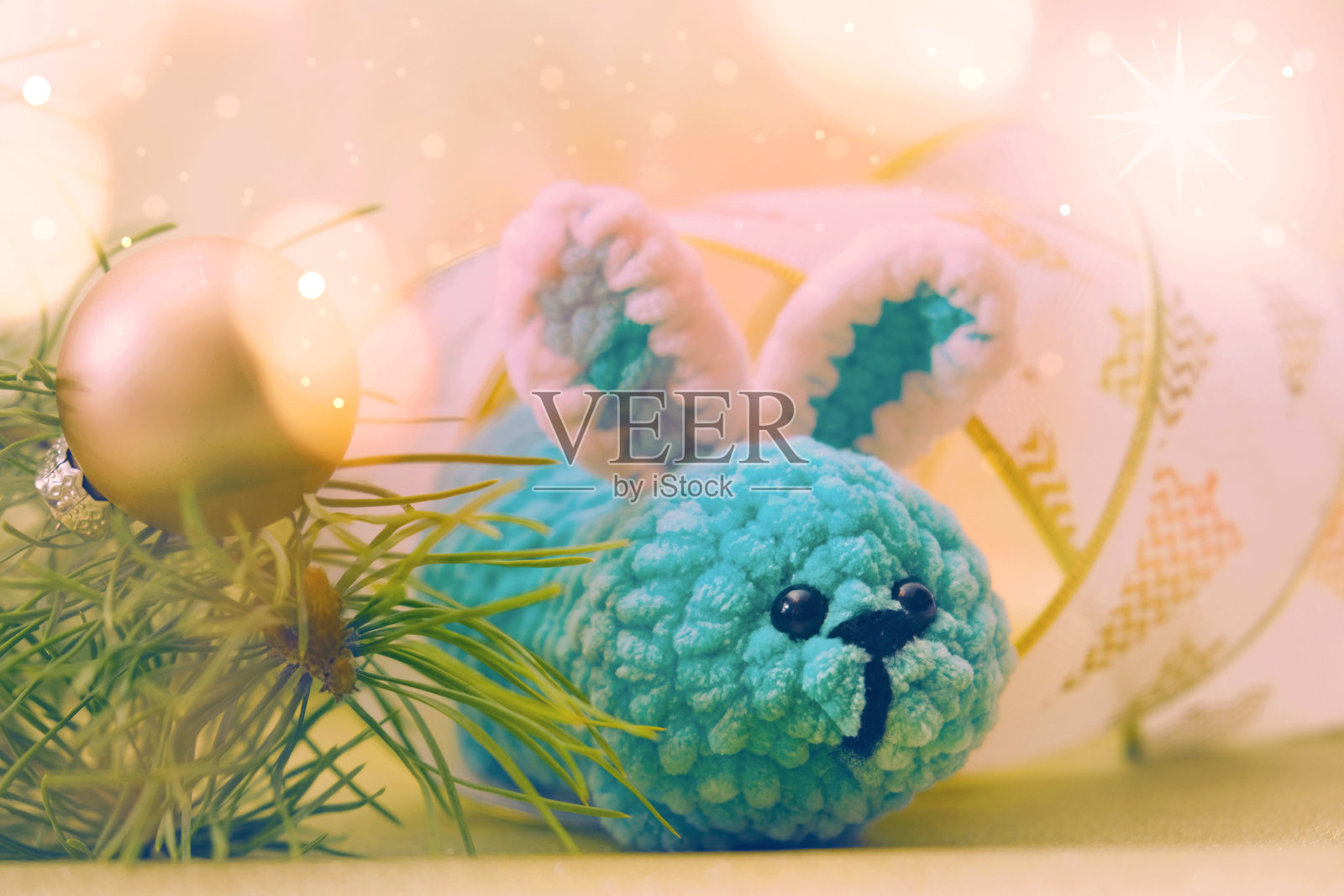 新年装饰。金色的灯光。圣诞卡片上有有趣的玩具兔子。新年快乐照片摄影图片