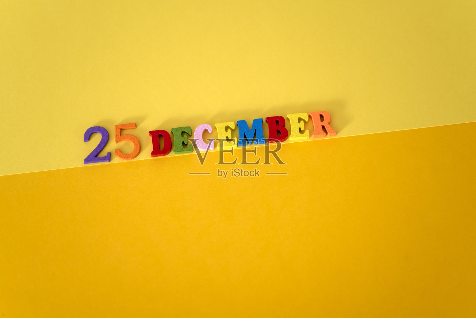 12月25日，黄色和纸质背景，木质和彩色字母，并留有文字空间。照片摄影图片