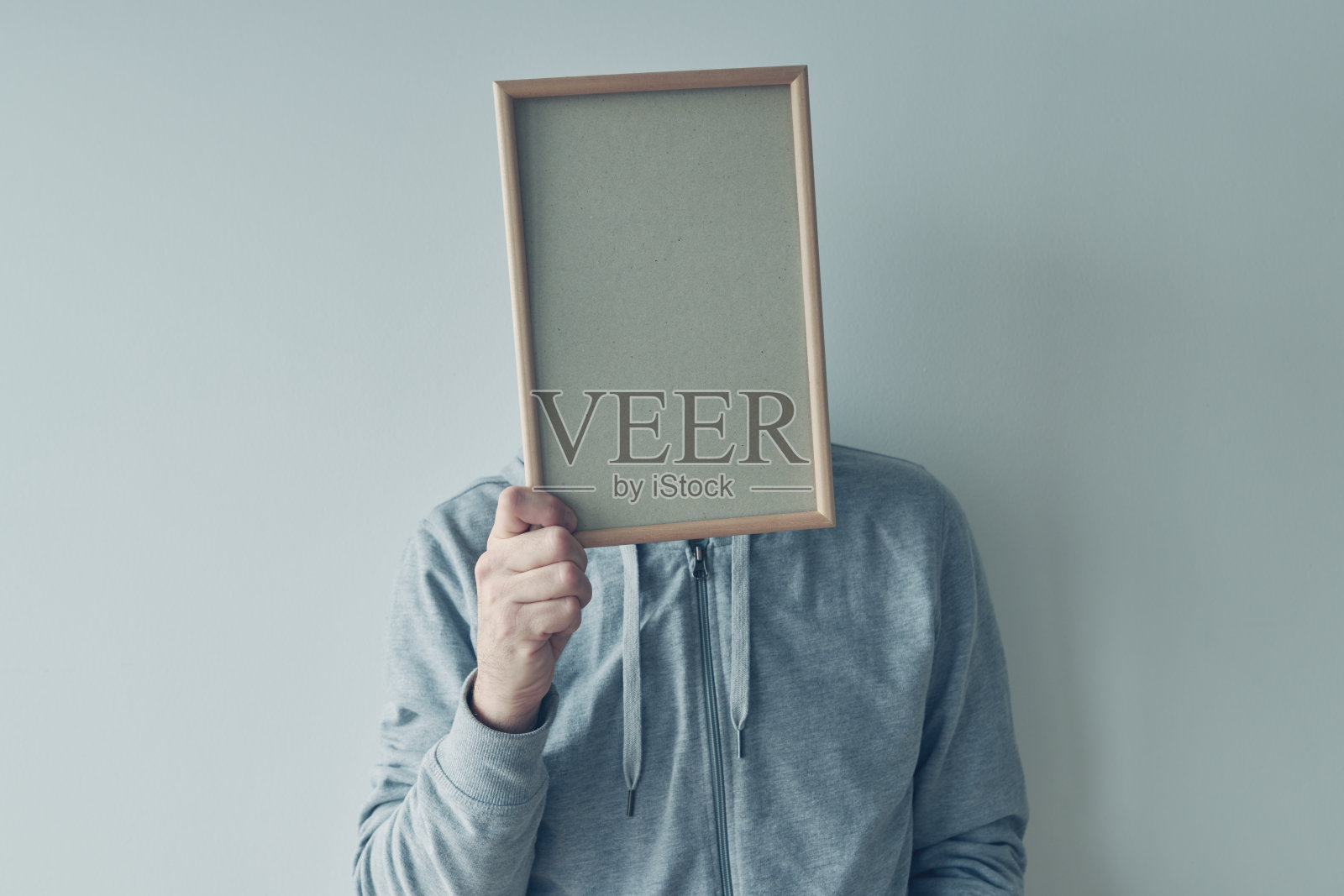 漫不经心的男子拿着空白相框在他的面前作为复制空间照片摄影图片