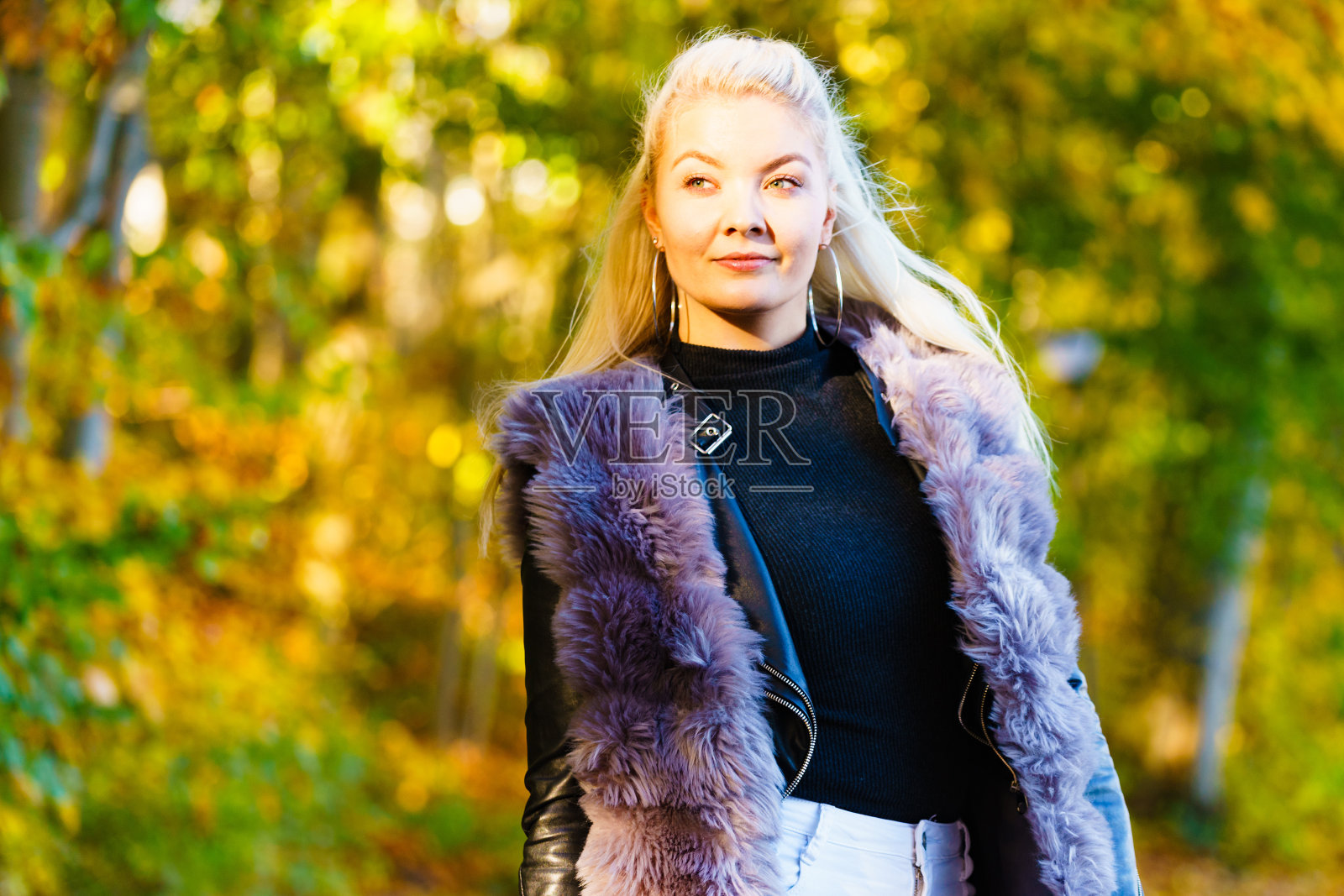 时尚女子走在秋天的公园里照片摄影图片