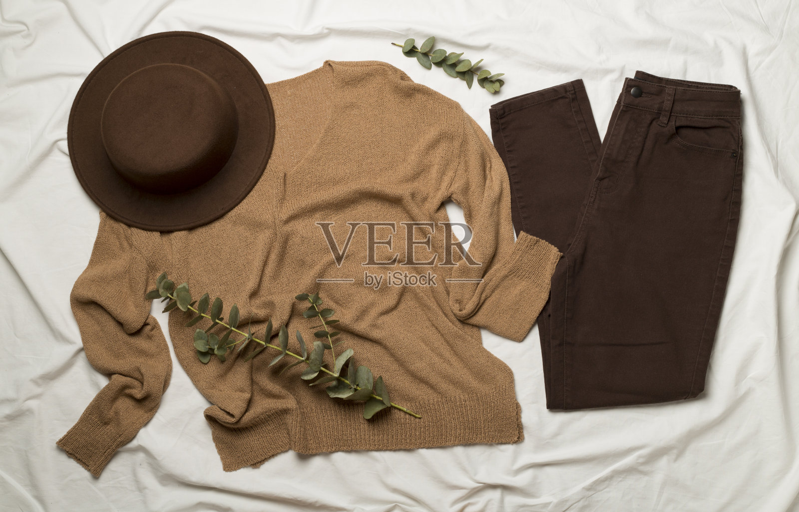 平躺与女性休闲装在白色床单上，顶视图照片摄影图片