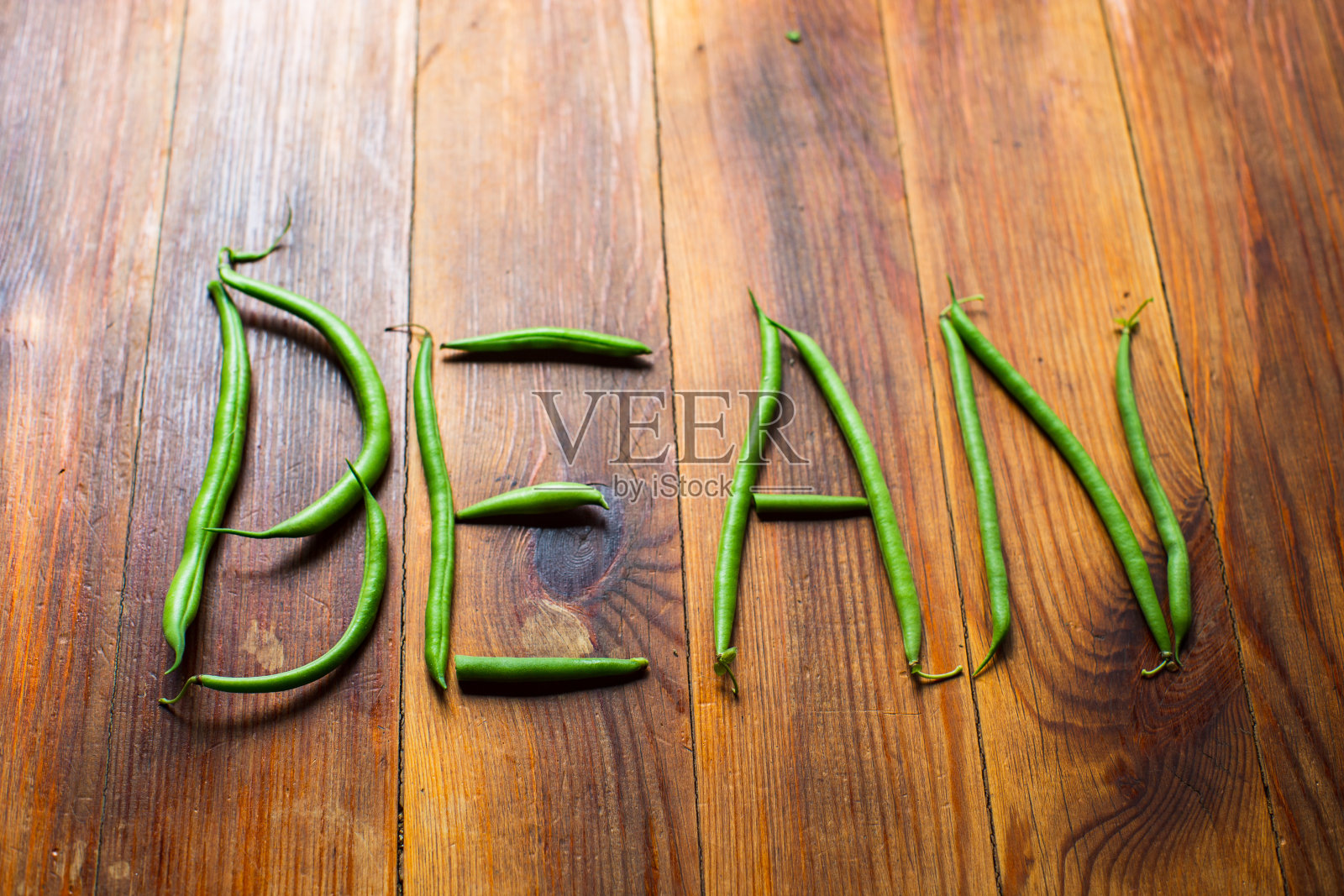 单词beans由木桌上的豆荚制成。种植园工作。秋收与健康有机食品理念紧密结合，选择性聚焦照片摄影图片
