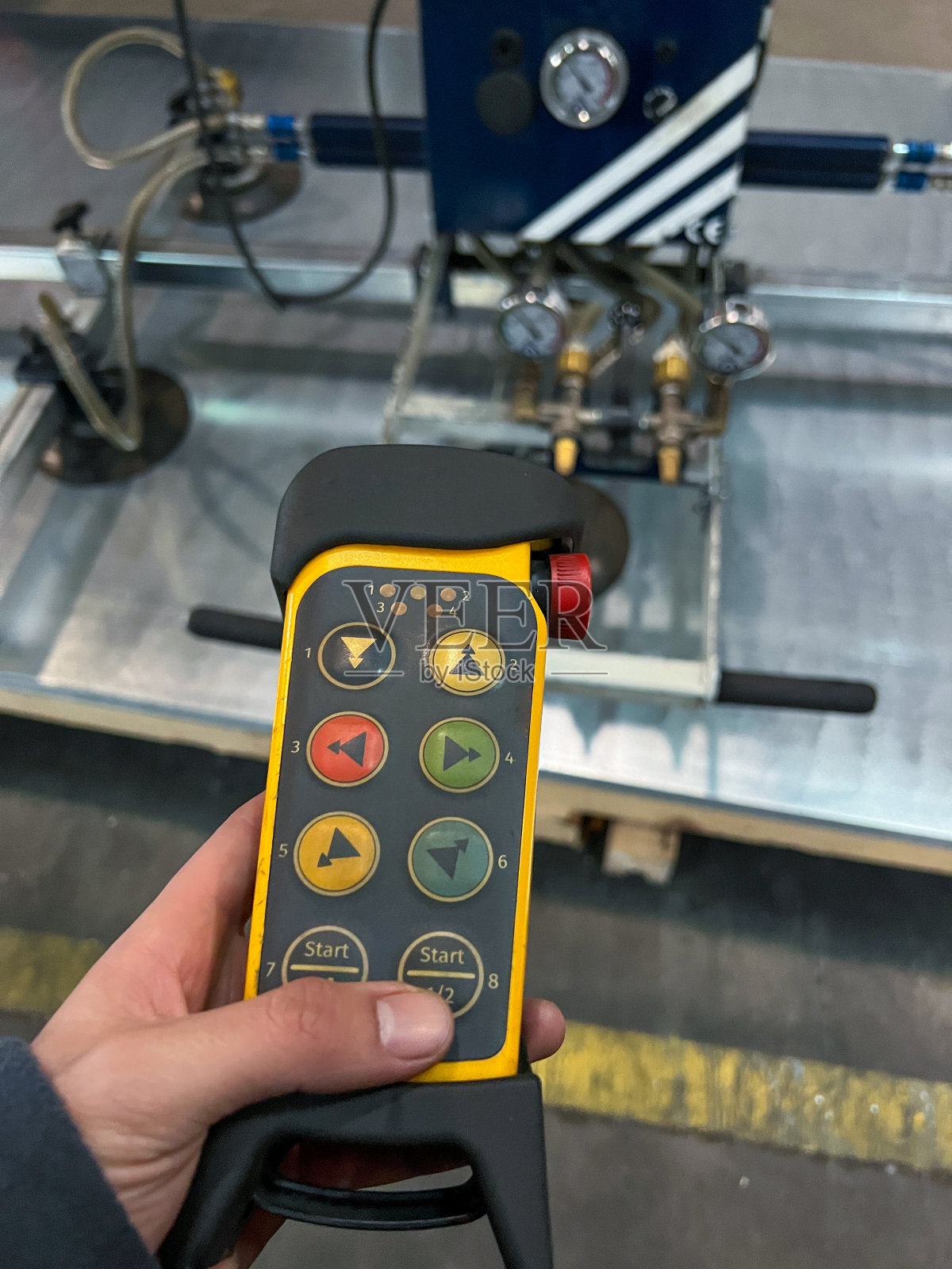 垂直特写一个无法辨认的工人使用远程控制使用吸盘机运输大型金属片照片摄影图片