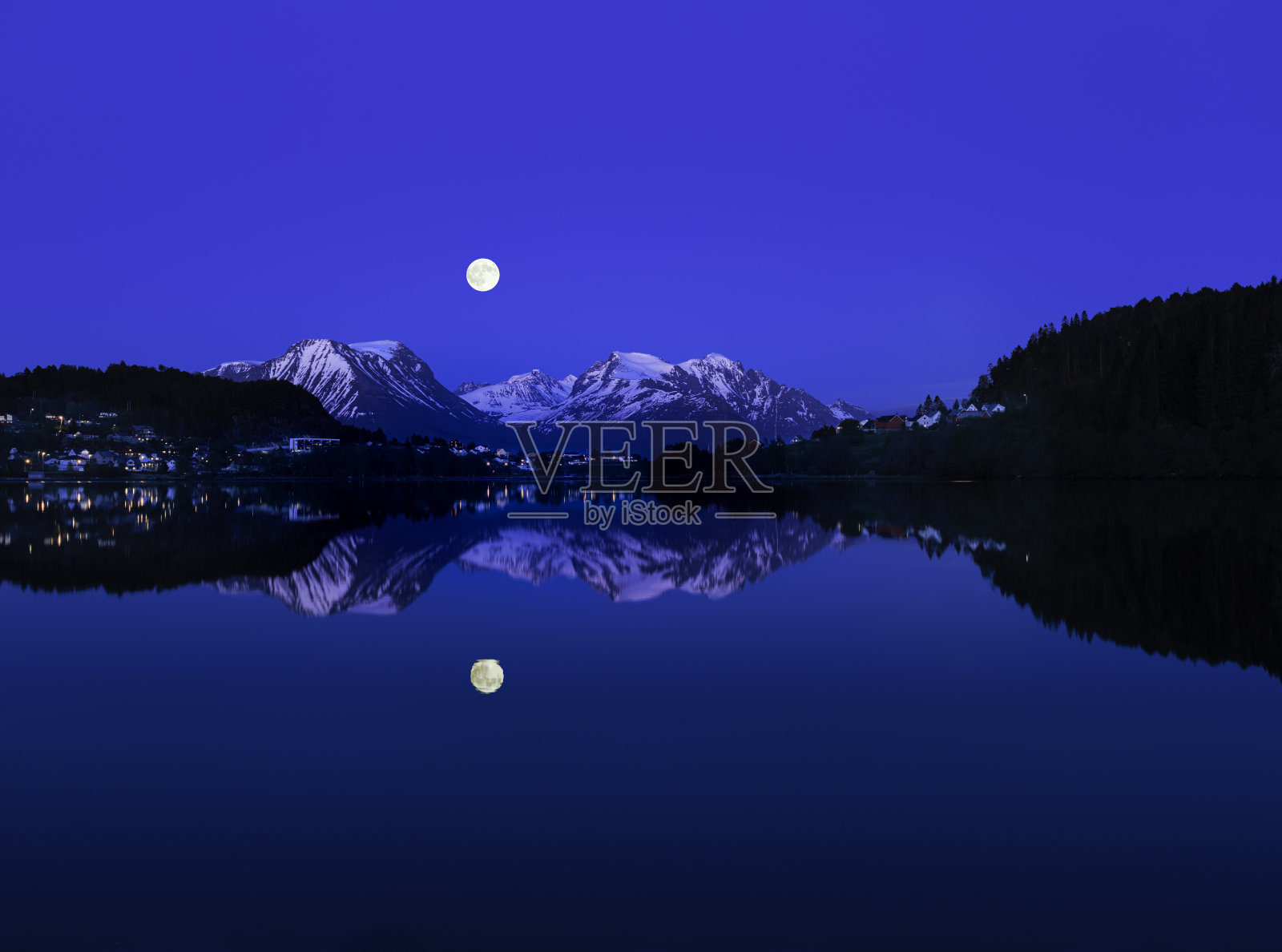 挪威山脉上的月亮倒映在湖面上照片摄影图片