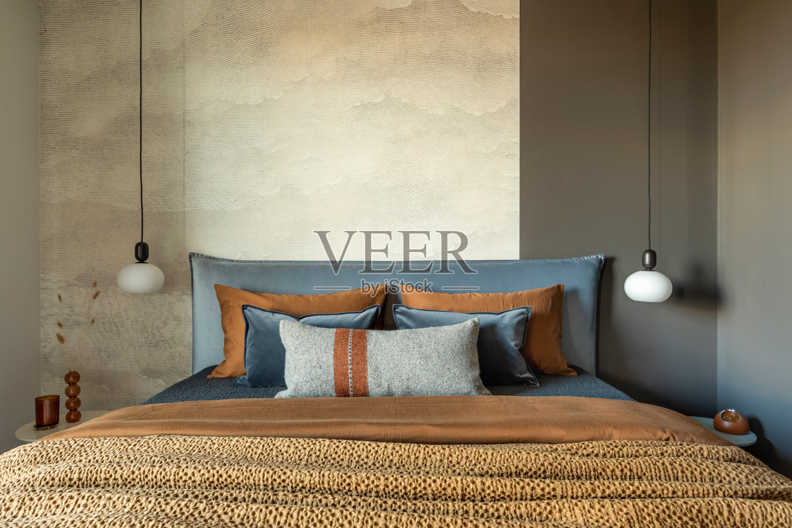 现代卧室室内的时尚组成。床，创意灯和优雅的个人配饰。混凝土墙。布朗sheeets。简约的概念。模板。照片摄影图片