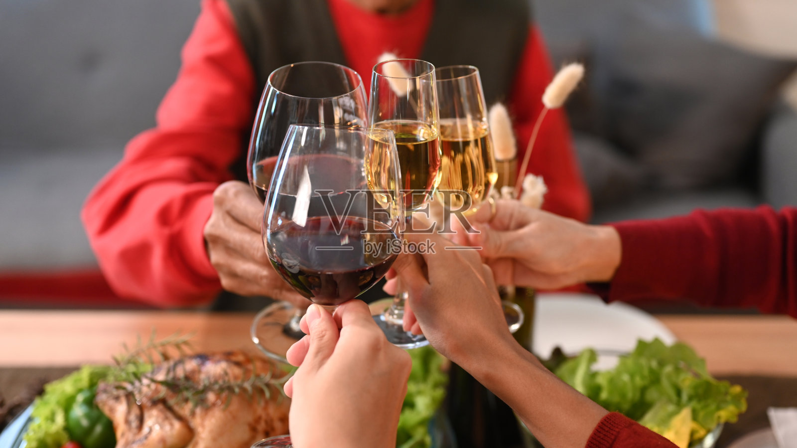 裁剪图像的一群人庆祝圣诞节，感恩节聚会晚餐和碰杯酒。照片摄影图片
