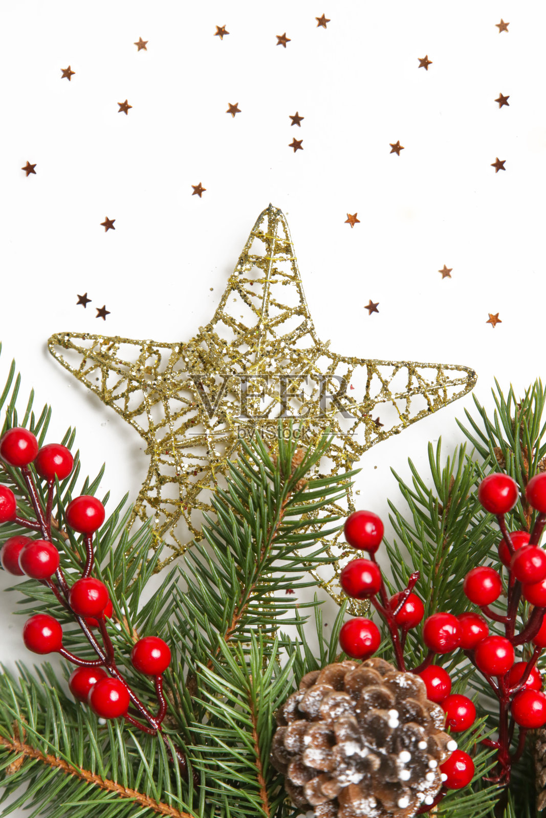 金色圣诞星形装饰和树枝与红色浆果，近距离照片摄影图片