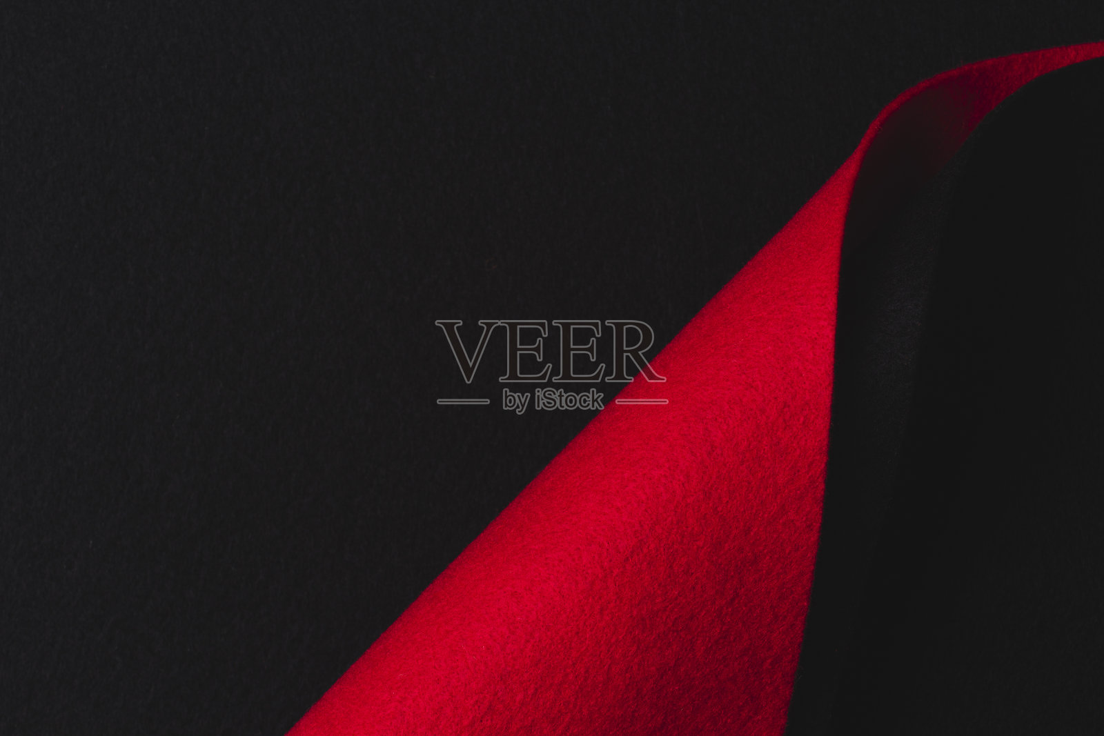 抽象的几何毛毡纹理背景。创意几何曲线毡纺织品背景在黑色和红色。俯视图，复制空间照片摄影图片