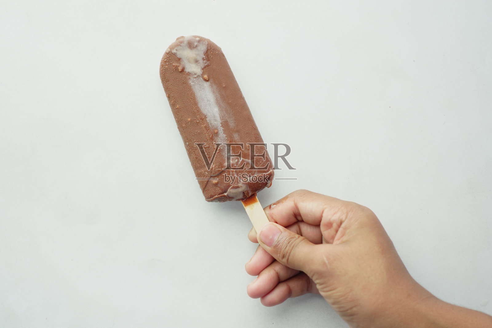 人手拿着冰淇淋在白色背景与复制空间照片摄影图片