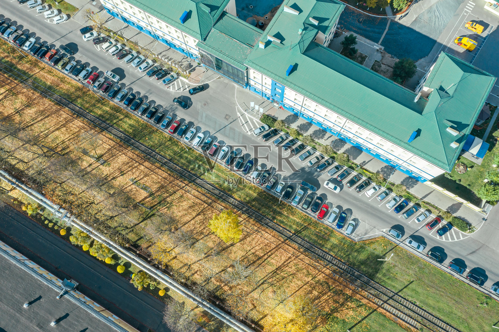 办公楼和停车场，有停放的汽车。阳光明媚的城市风景。照片摄影图片