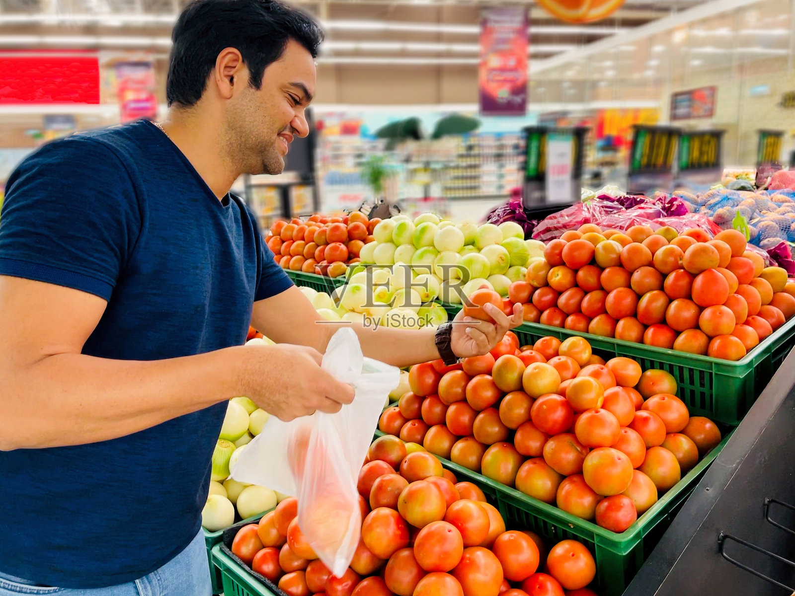 一个男人在市场上挑选西红柿照片摄影图片