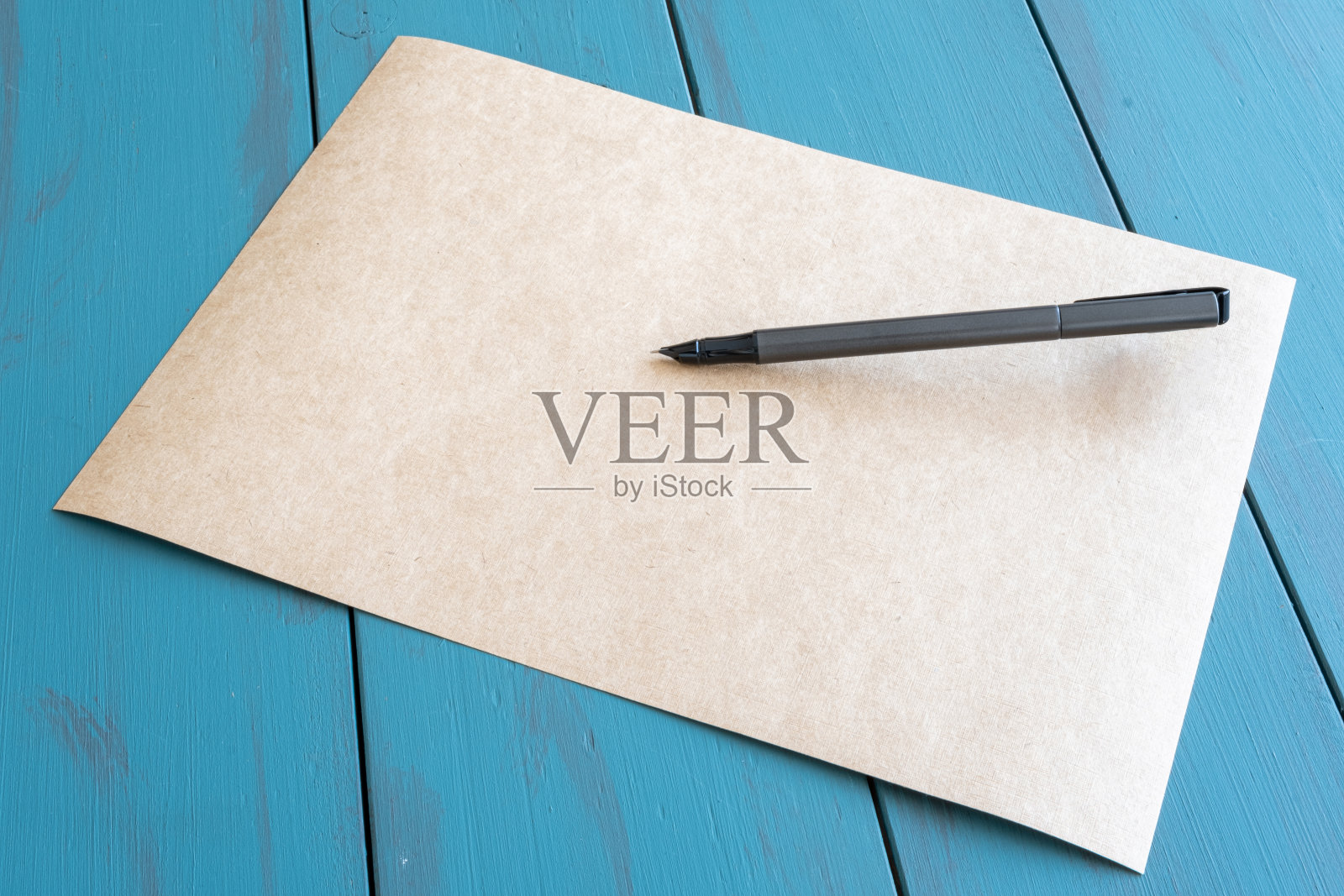 灰色钢笔在空的棕色纸上——侧视图。照片摄影图片