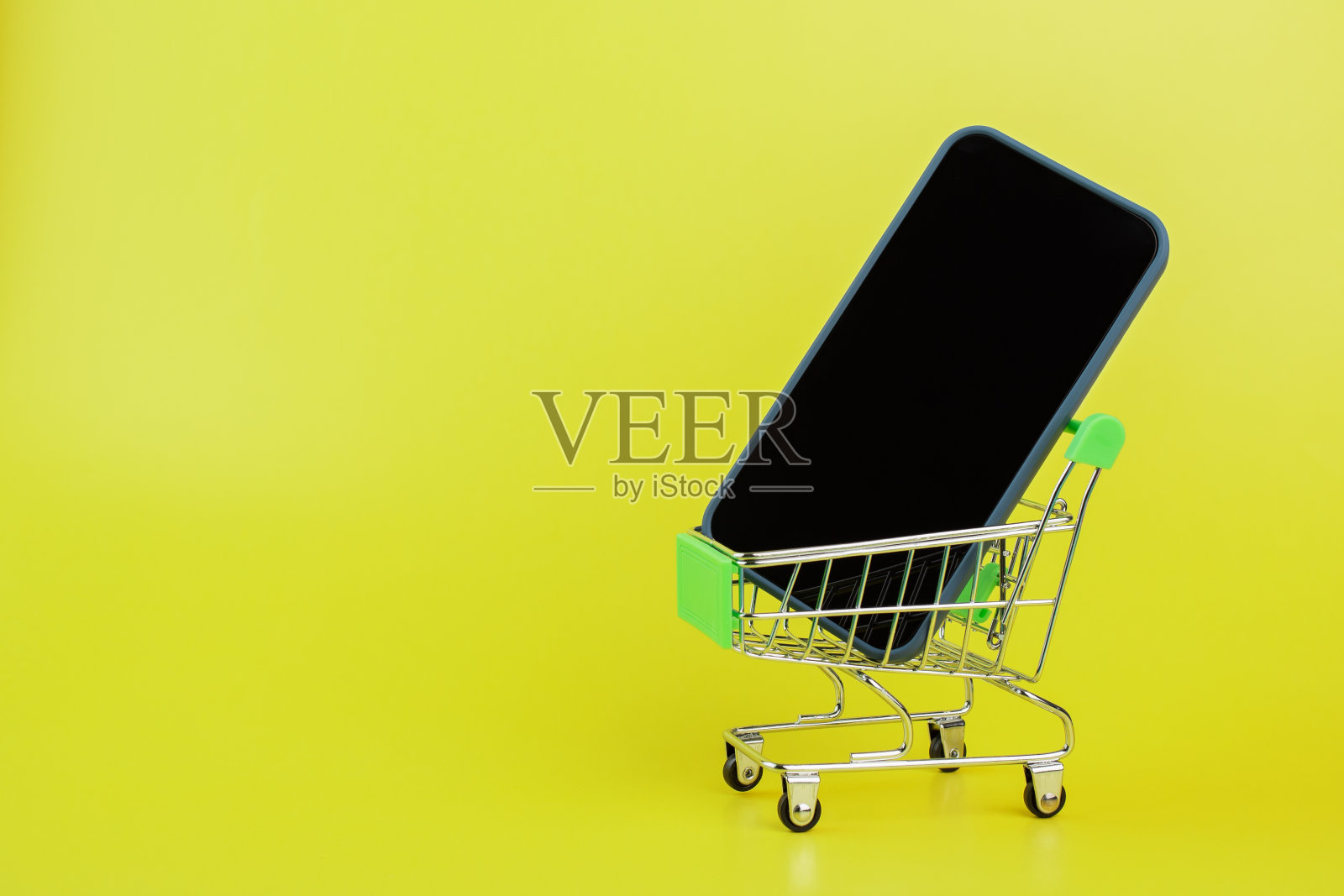 在超市手推车里的电话，黑色星期五，购买现代小工具，大减价，数字商店照片摄影图片