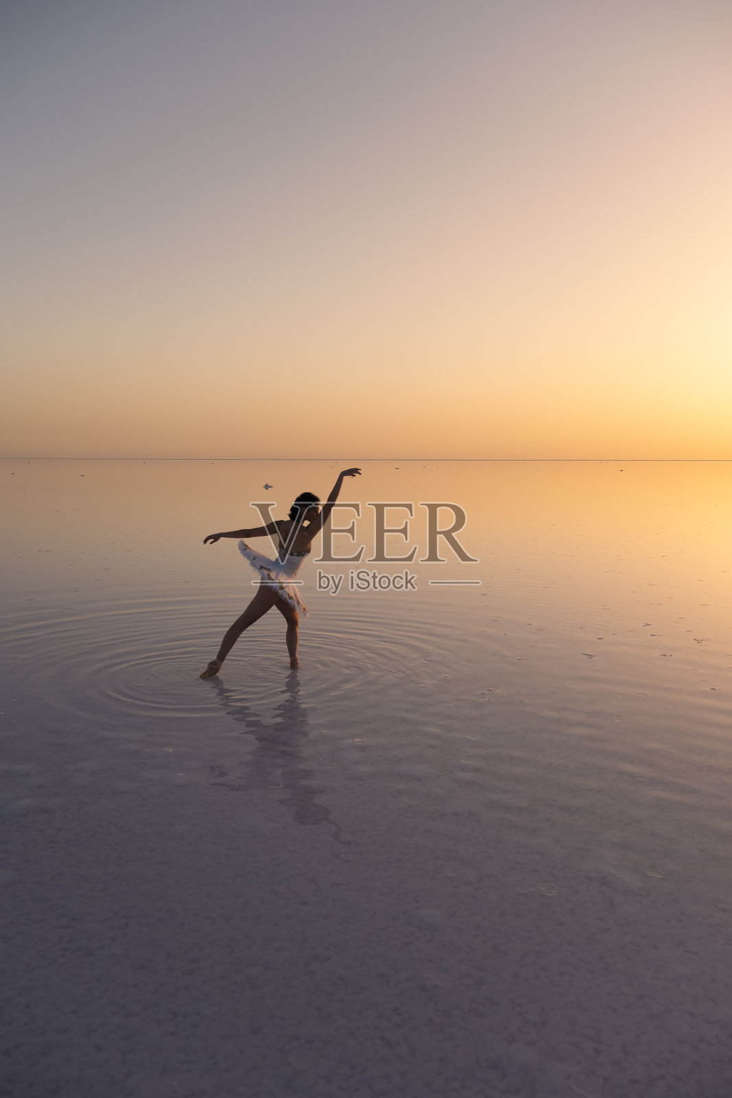 日落时分，芭蕾舞者在图兹湖上跳舞，她在水中的倒影照片摄影图片