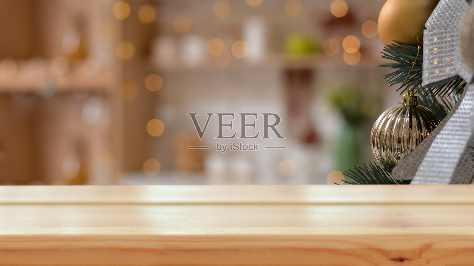 空木桌的背景是一个圣诞树枝与金色的球，圣诞厨房，新年的金色焦。圣诞快乐，新年快乐!准备好产品蒙太奇。模型。照片摄影图片