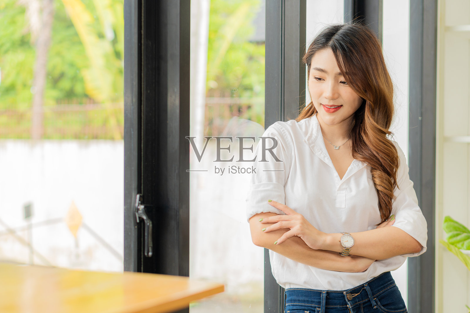 微笑的亚洲妇女站在她的双臂交叉看着相机在工作
自信地照片摄影图片