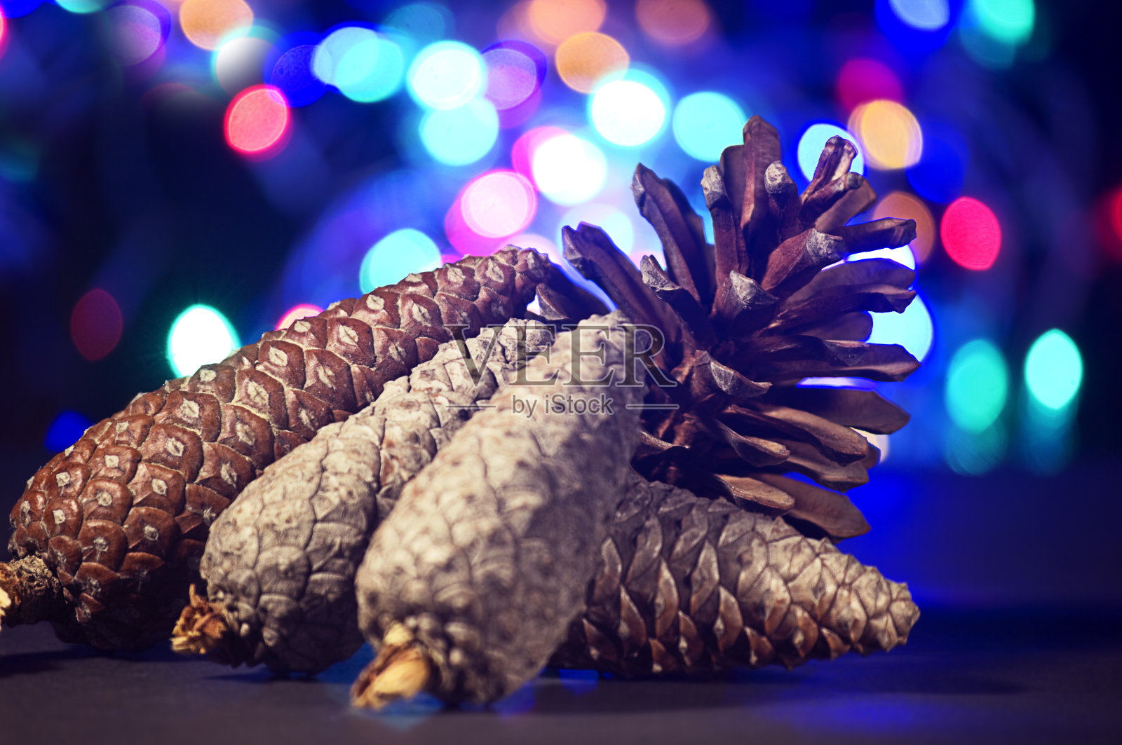 挂着彩灯的松果宣告着圣诞节的到来。照片摄影图片