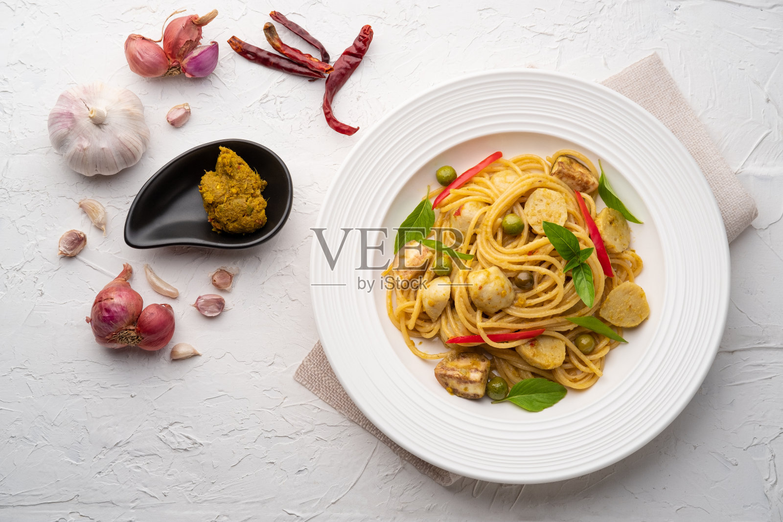 意大利面配绿咖喱酱鱼丸照片摄影图片