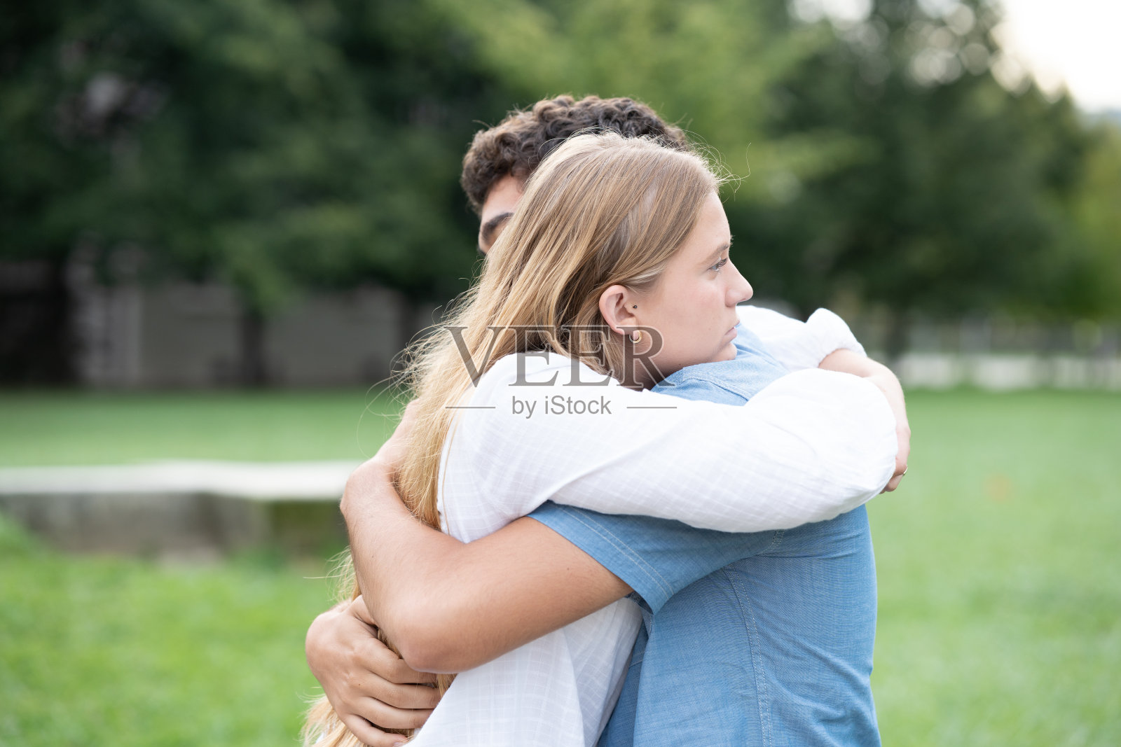 一对十几岁的情侣在公园里拥抱照片摄影图片