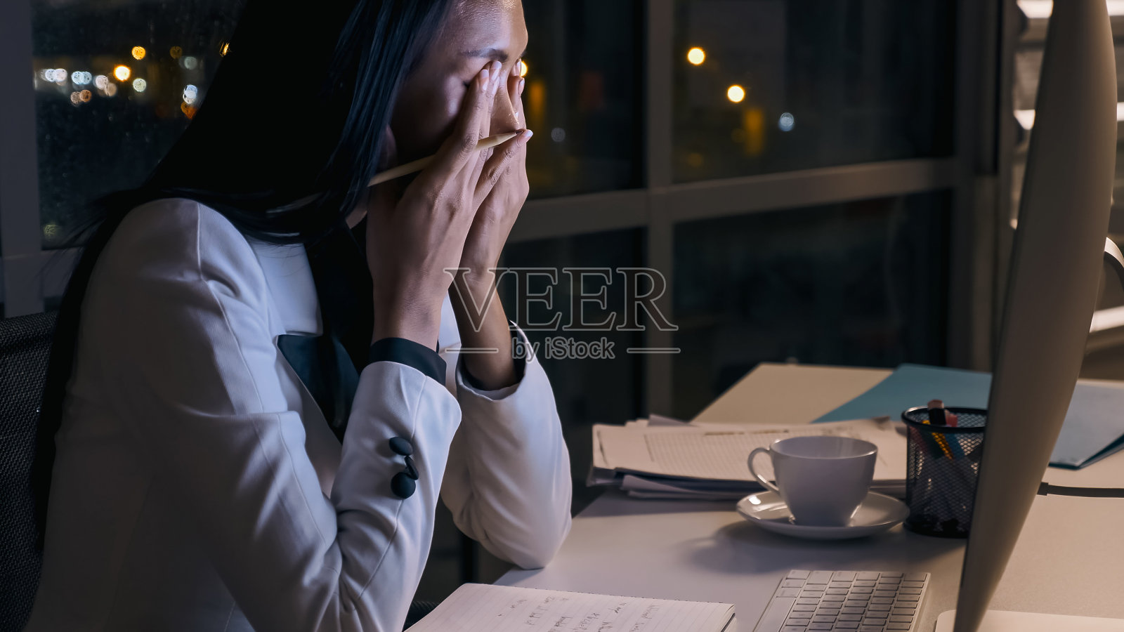 在办公室加班的焦虑的年轻亚洲女商人照片摄影图片