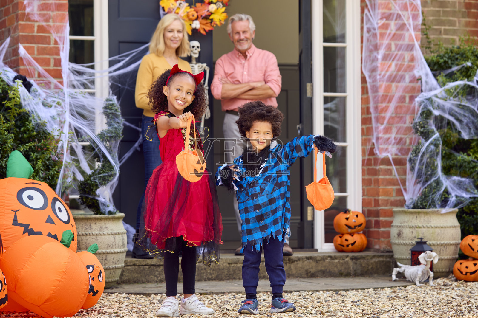 孙子孙女们在万圣节装扮去爷爷奶奶家玩“不给糖就捣蛋”的画像照片摄影图片