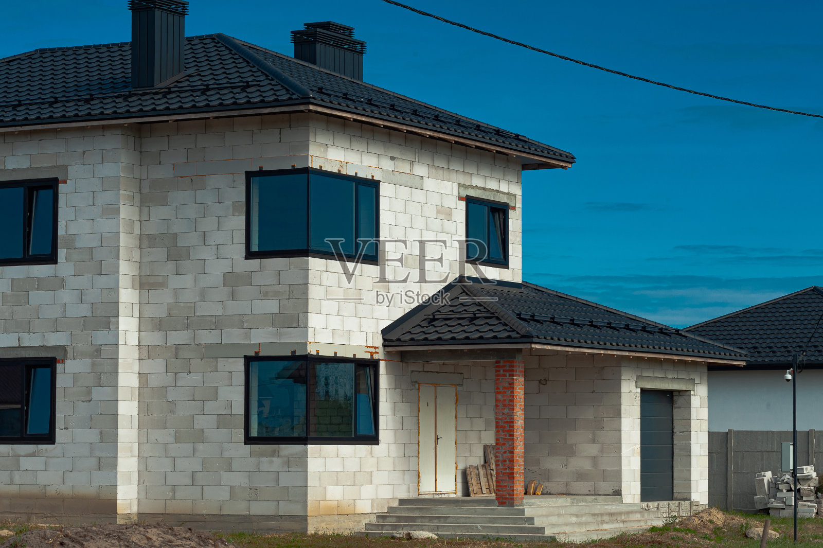 白色泡沫混凝土块建造的房屋工地。建造新的家园框架。照片摄影图片