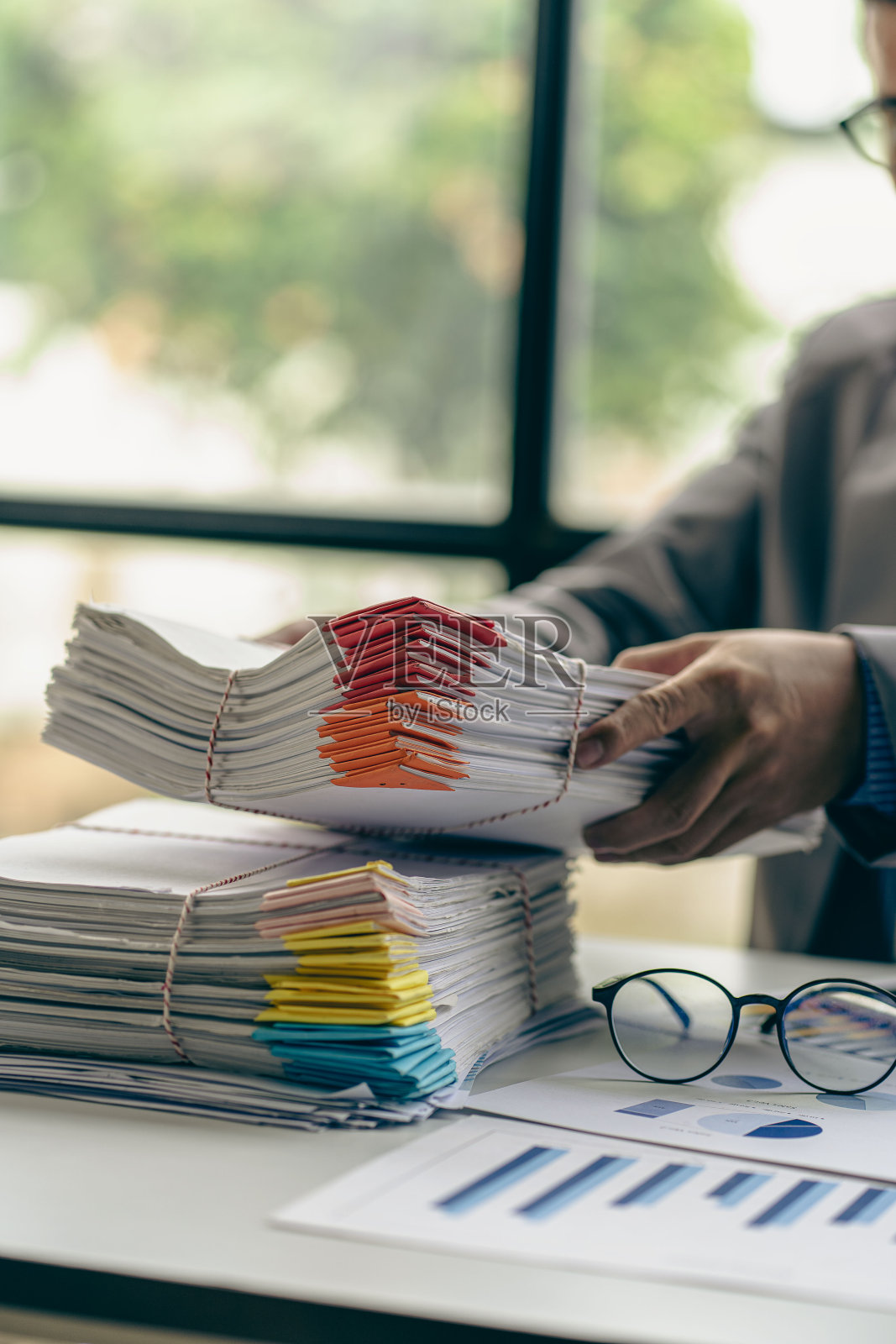 从事金融工作的商人办公桌上堆着一堆未完成的文件照片摄影图片