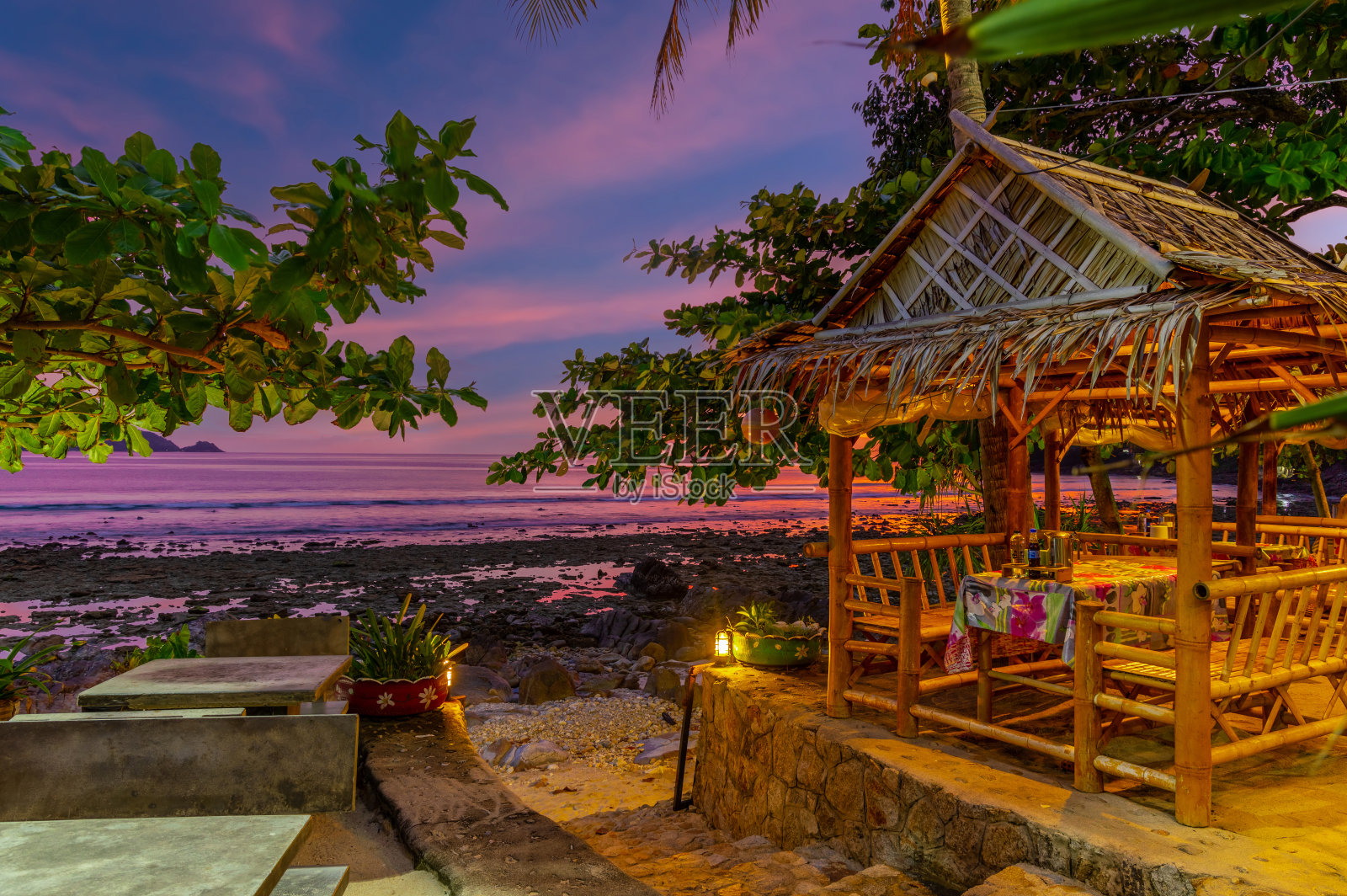 在泰国普吉岛的Kalim海滩上的日落。可爱的蓝绿色海水，郁郁葱葱的青山，五彩缤纷的天空照片摄影图片