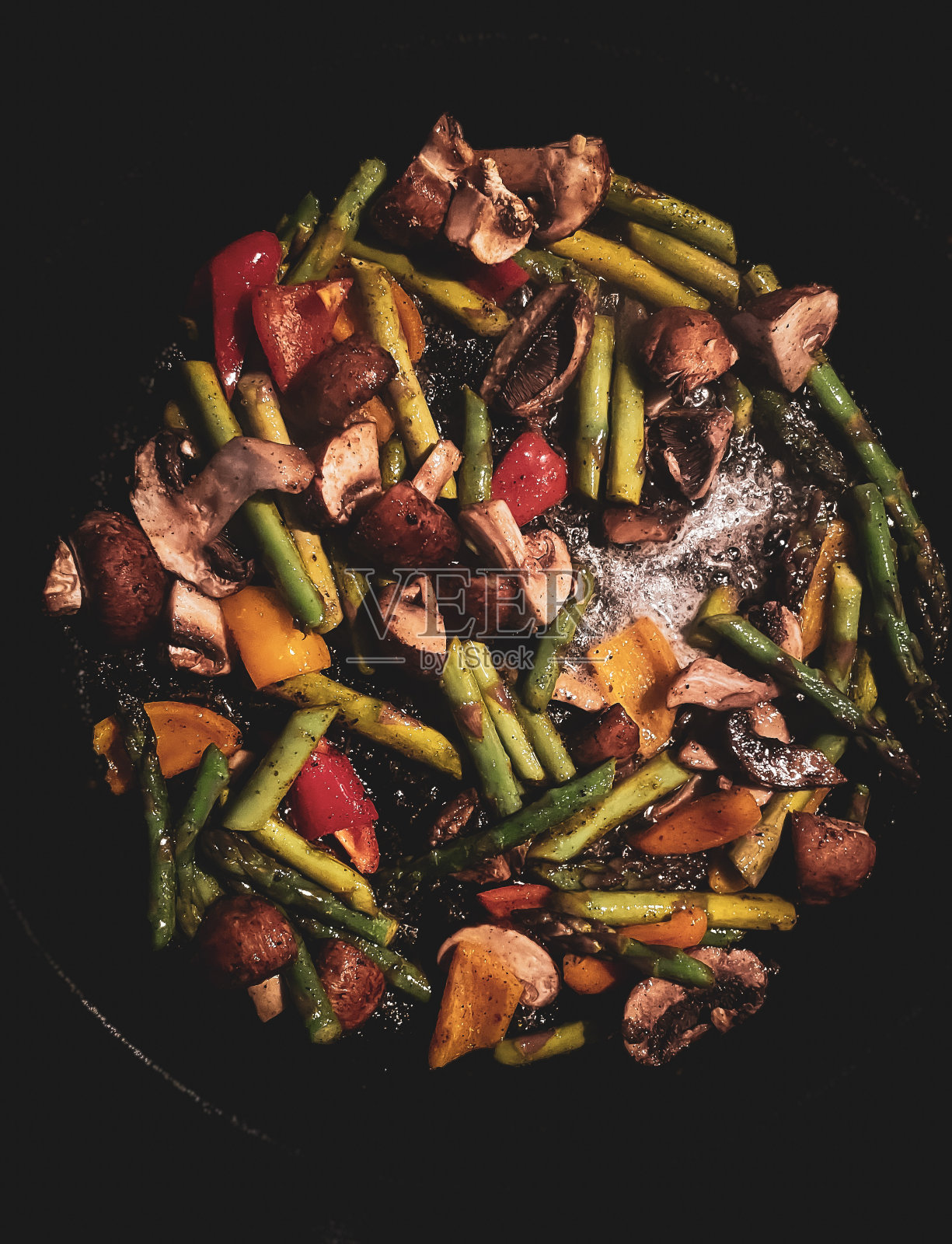 蔬菜在热的铸铁煎锅里滋滋作响照片摄影图片