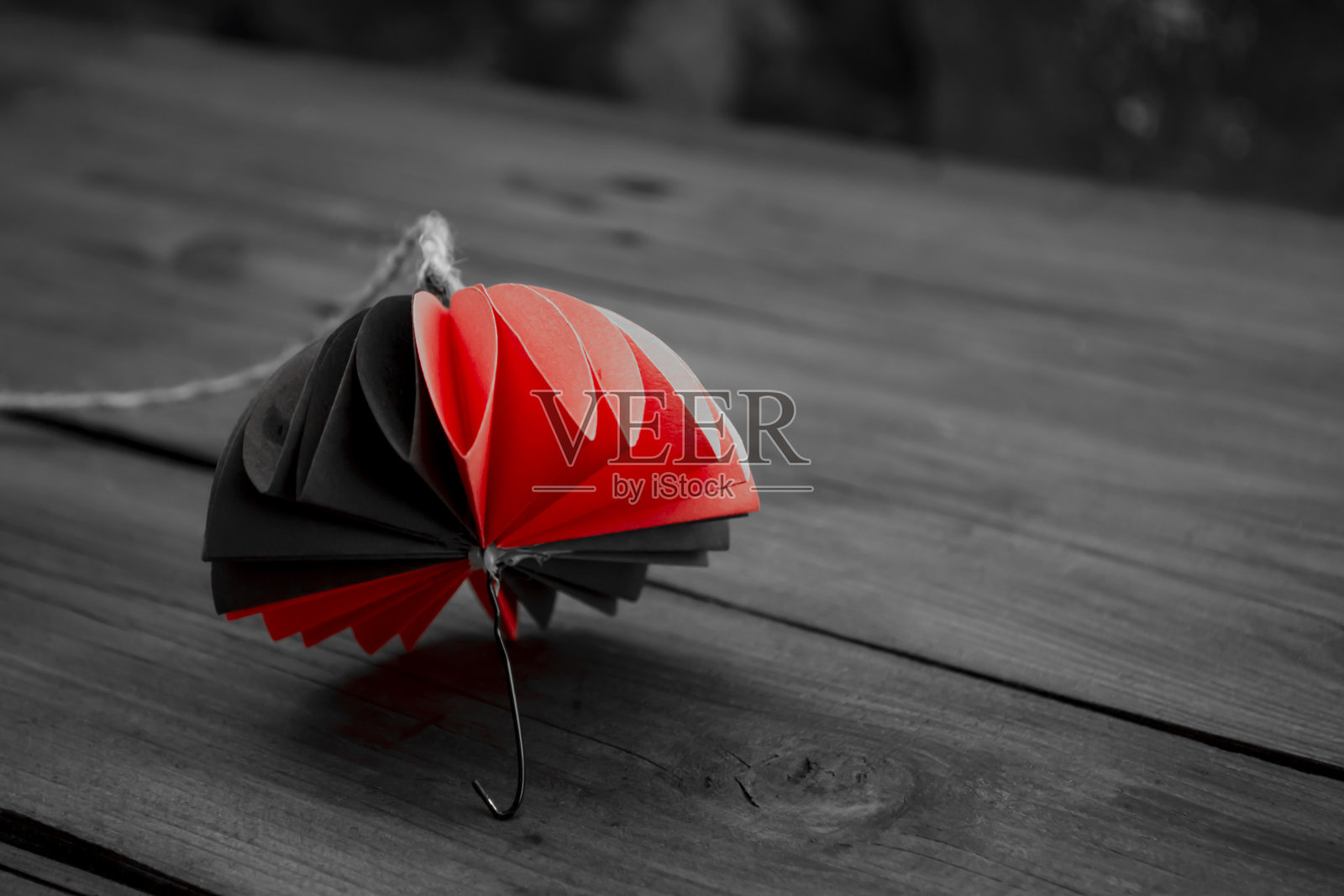 木桌上的纸做的伞。折纸是一把伞。灰色背景上的彩色伞。双色厚实的秋天装饰。秋天纸工艺品。照片摄影图片