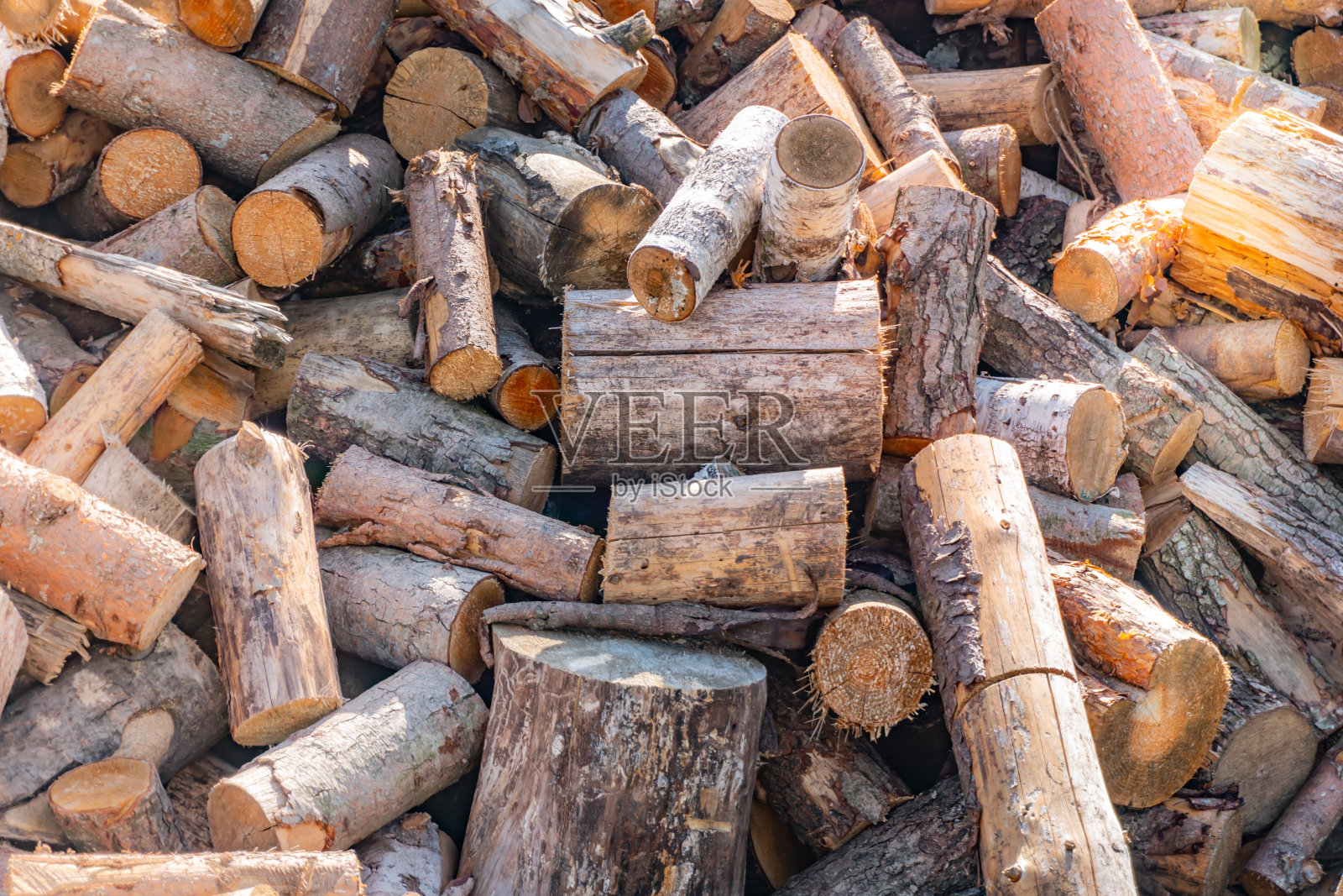 一大堆柴火锯成的背景，一棵锯成的树，准备过冬的柴火，柴火为伐木工冬日的阳光照射照片摄影图片