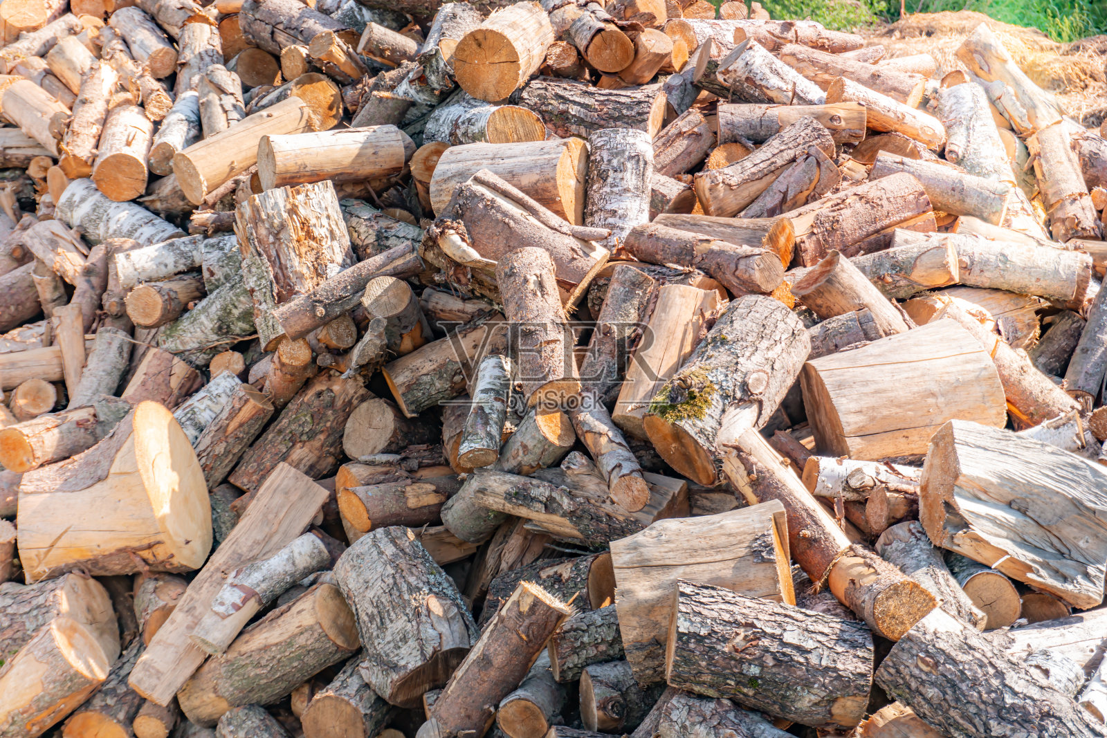 一大堆柴火锯成的背景，一棵锯成的树，准备过冬的柴火，柴火为伐木工冬日的阳光照射照片摄影图片