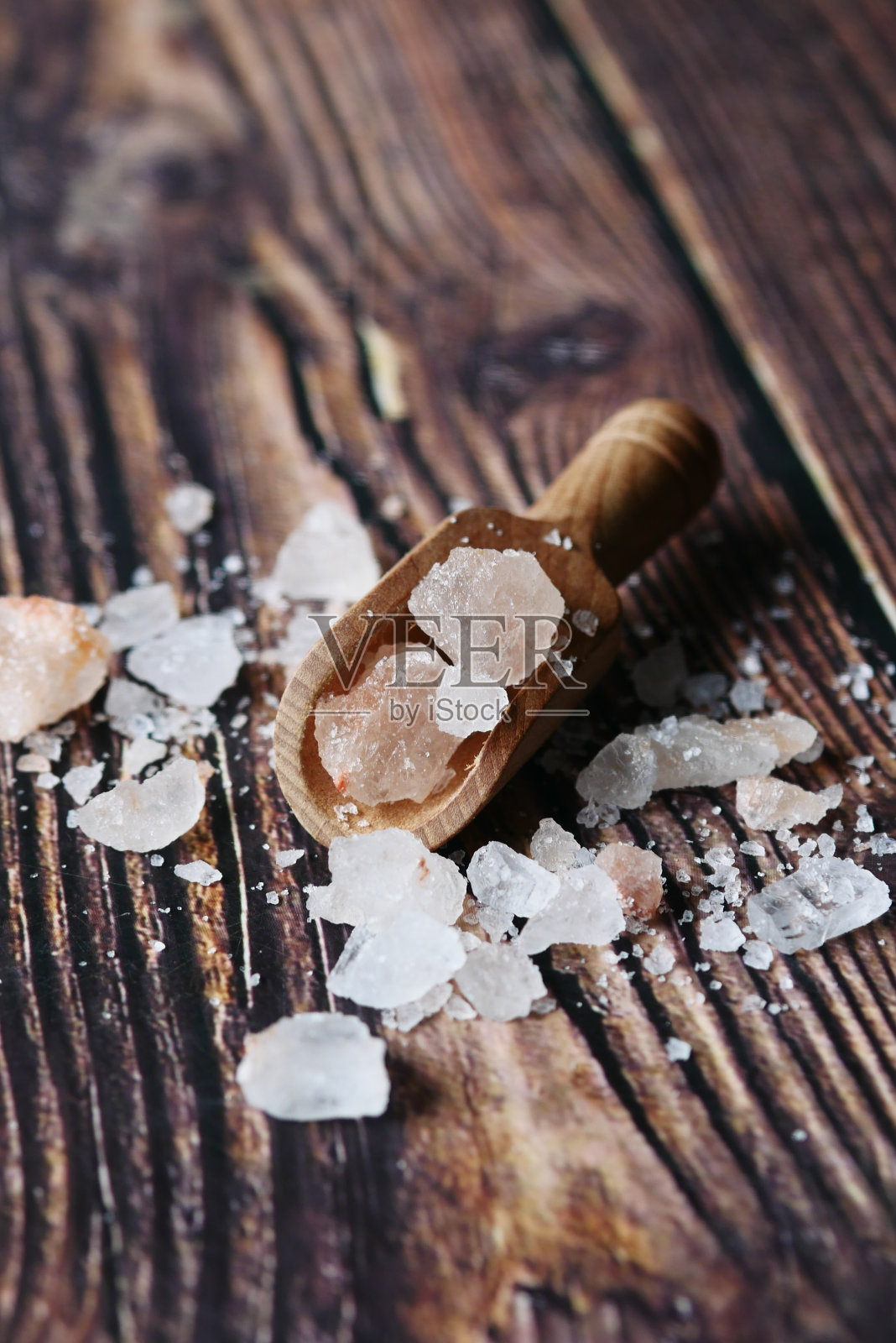 在桌子上的木勺里的粉色岩盐特写照片摄影图片