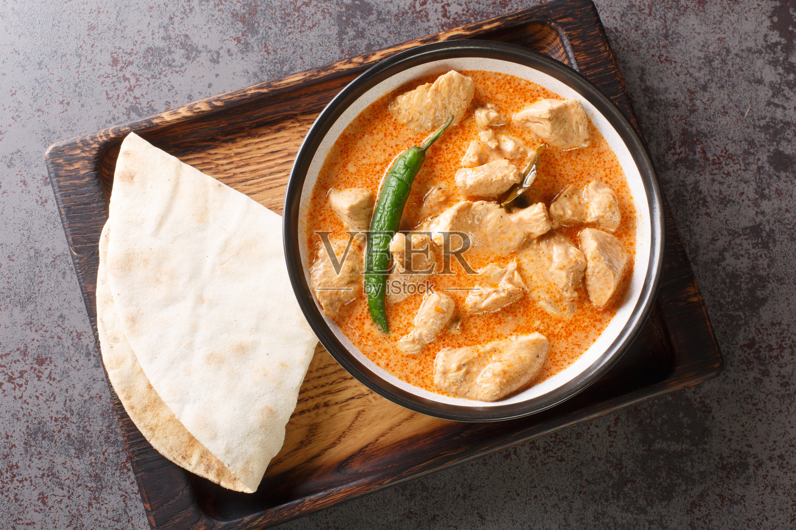 Kukul mas是一种传统的斯里兰卡咖喱鸡，由洋葱、姜、大蒜、姜黄、印度香料、辣椒粉、椰奶和番茄制成。水平的俯视图照片摄影图片