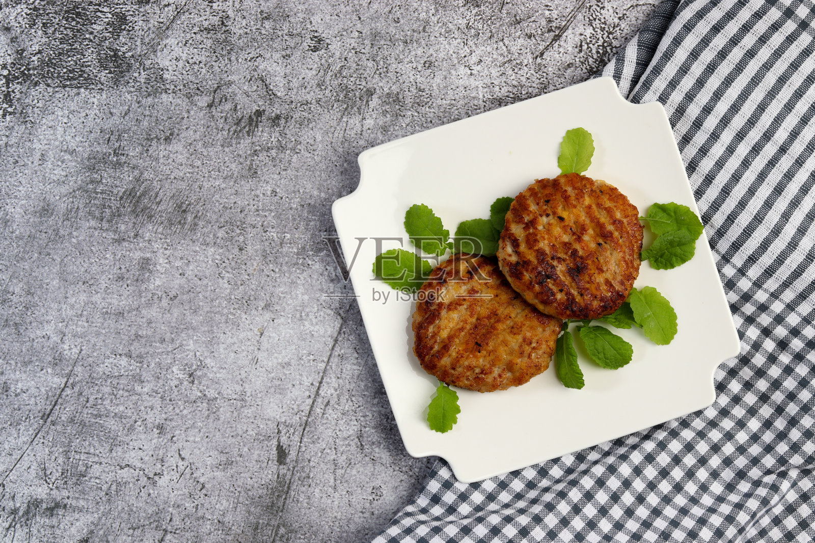 火鸡肉饼或肉片，放在深色底色的白色方盘上。俯视图，平铺照片摄影图片