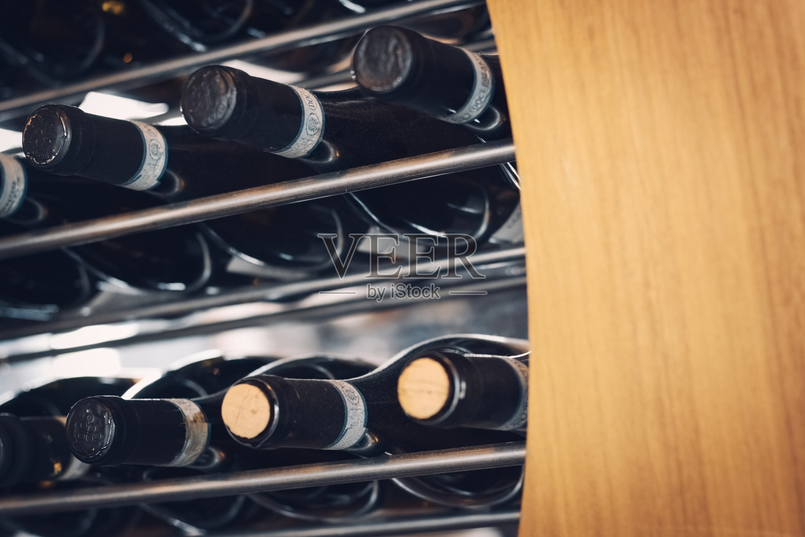 酒瓶水平放置在酒架上，酒架上有木条和金属条照片摄影图片