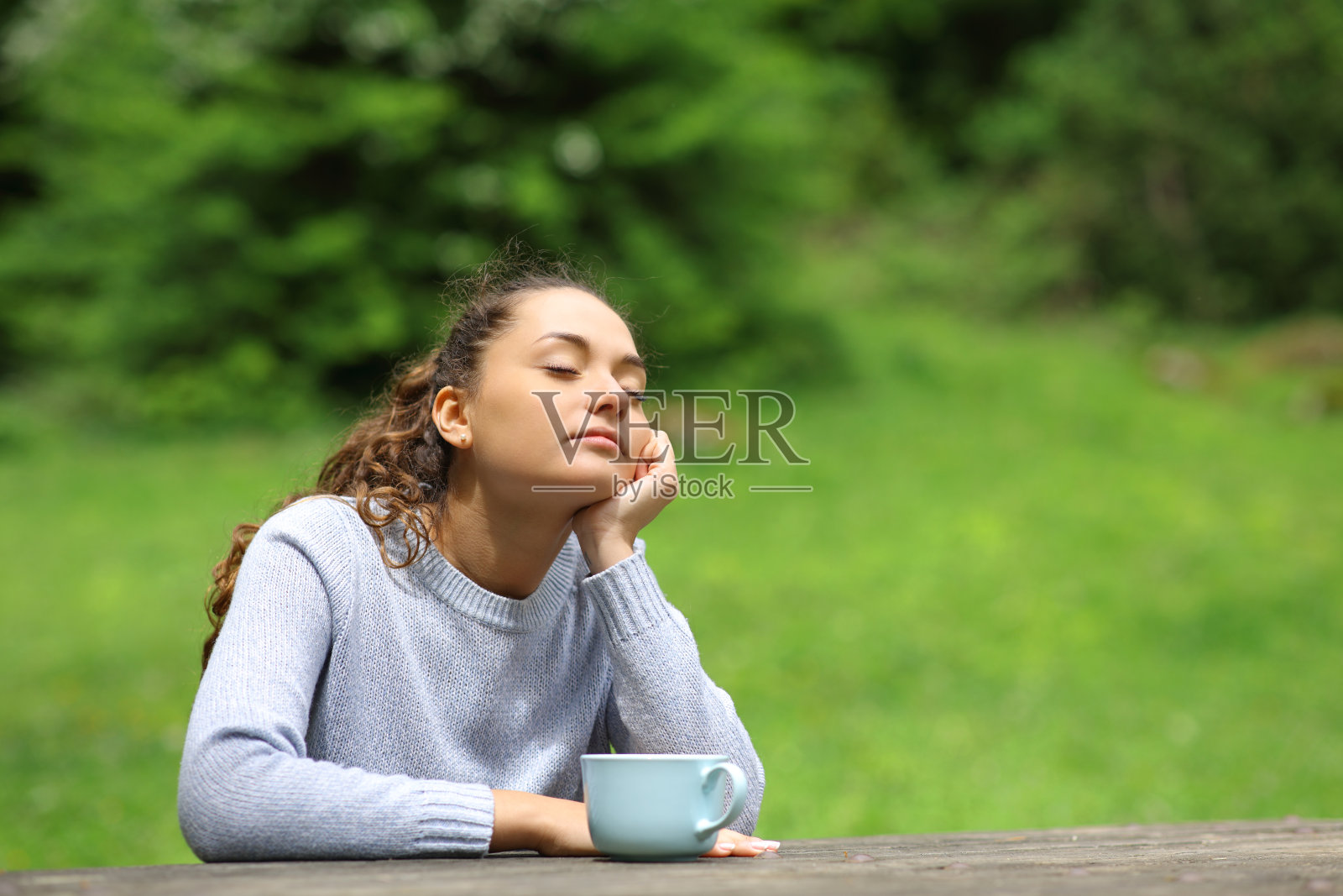 一个女人在公园里喝酒放松照片摄影图片