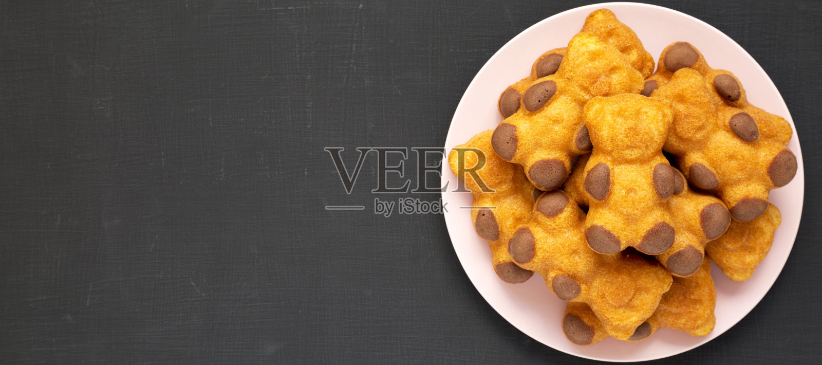 自制甜饼干在一个黑色背景的粉红色盘子上，俯视图。从上面，平躺，头顶。副本的空间。照片摄影图片