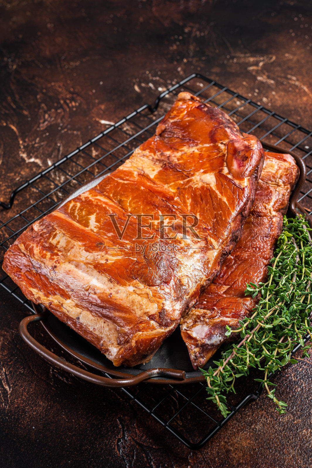 烟熏烤排骨，排骨放在厨房托盘里。黑暗的背景。俯视图照片摄影图片