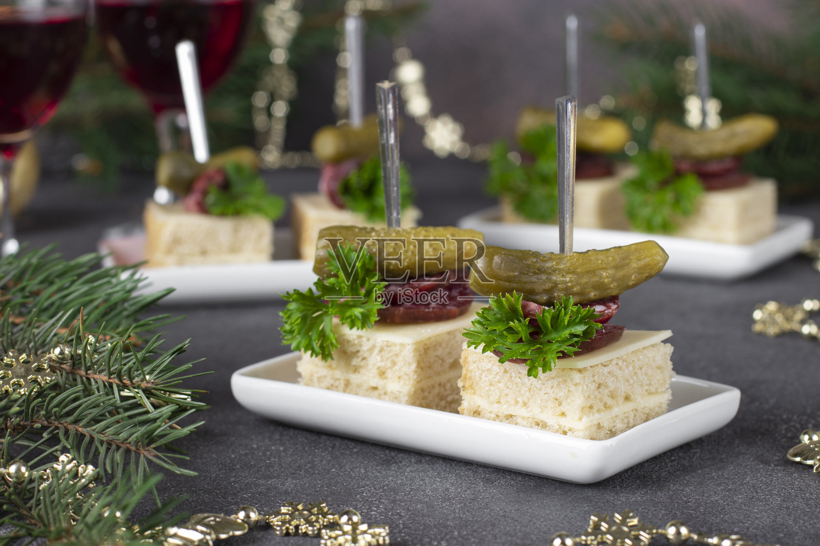 自制的小点心配小黄瓜和烟熏香肠配白面包配灰色背景的奶酪，节日的开胃菜照片摄影图片