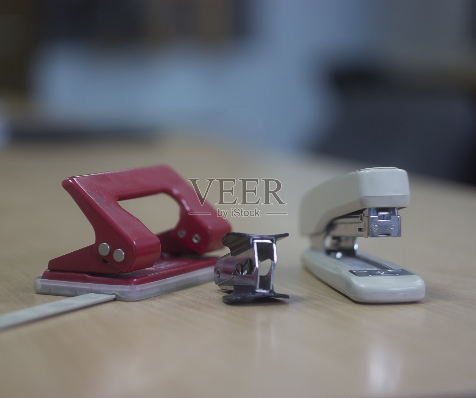 办公文具放在桌子上。订书机，反订书机和打孔机照片摄影图片