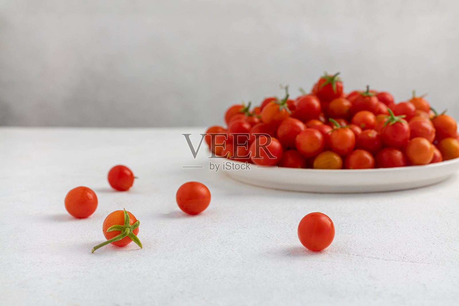 红色的圣女果在白色的盘子上放上清淡，极简主义照片摄影图片