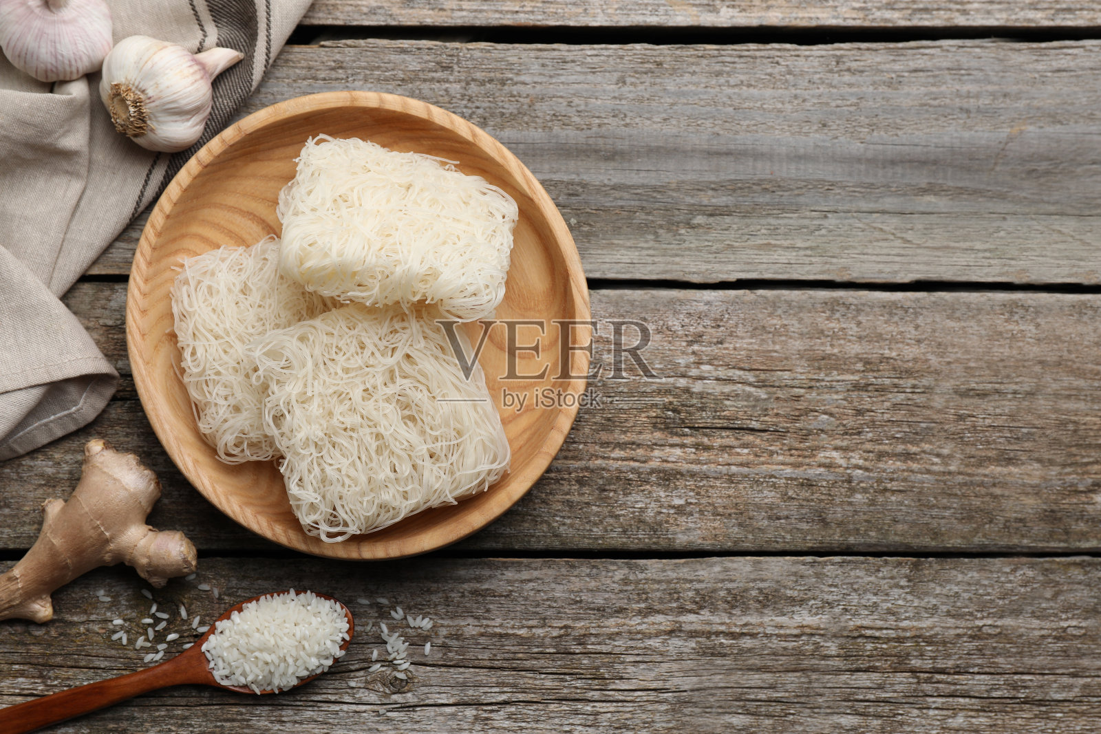 一碗干米粉和食材放在木桌上，平铺。空间的文本照片摄影图片