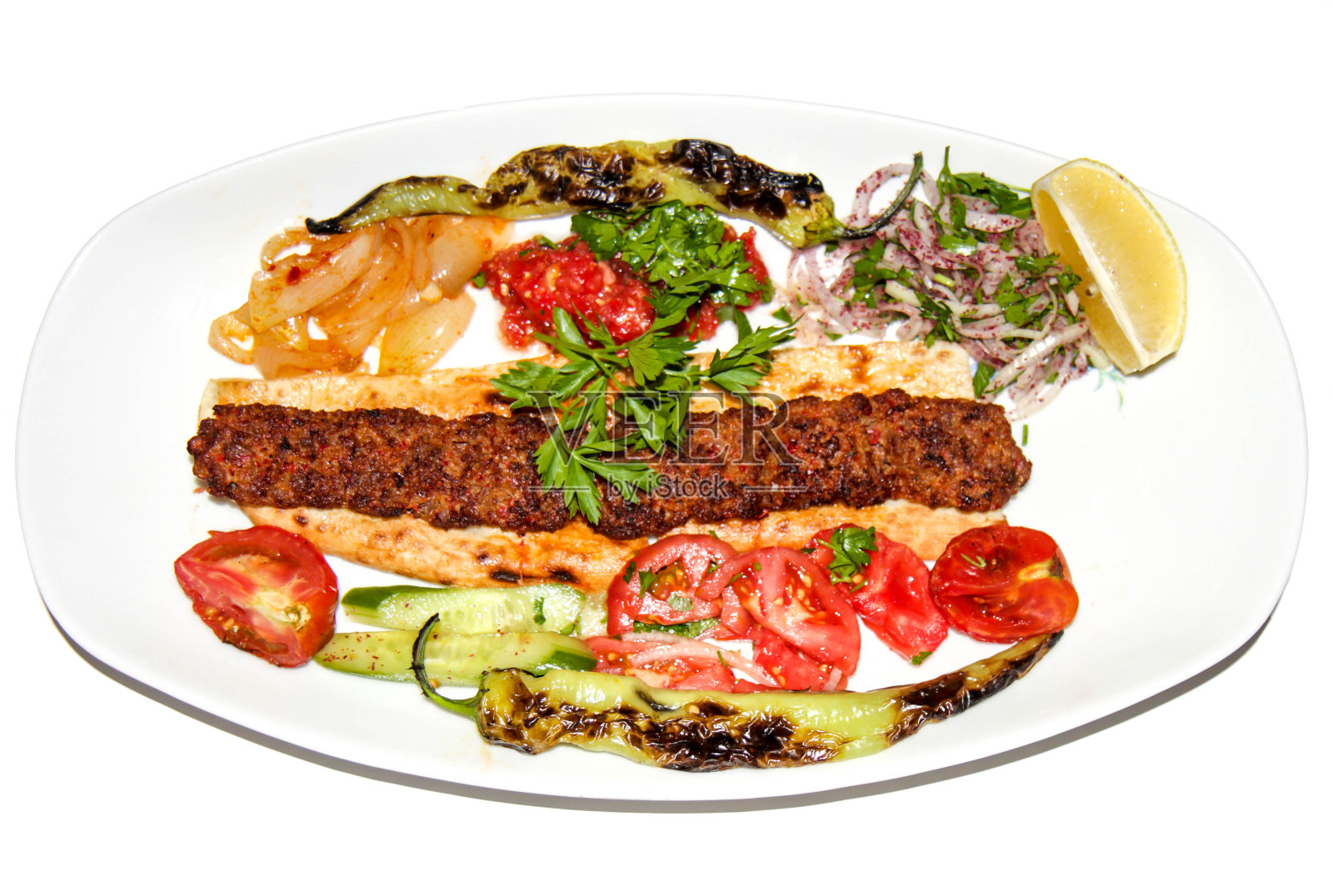 在土耳其的阿达纳，烤辣阿达纳烤肉串与沙拉和装饰隔离在白色背景照片摄影图片