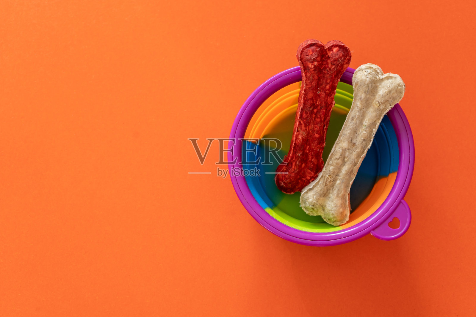 橙色背景的狗骨头碗。关闭了。附件为狗照片摄影图片