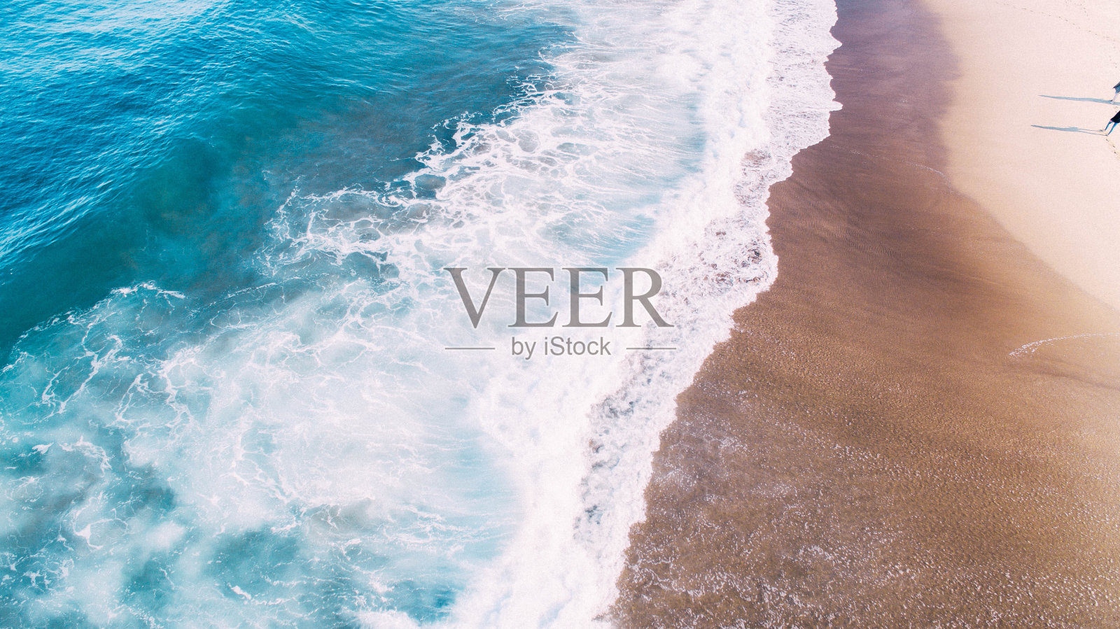 荒芜的海滩，海浪拍打着海岸照片摄影图片