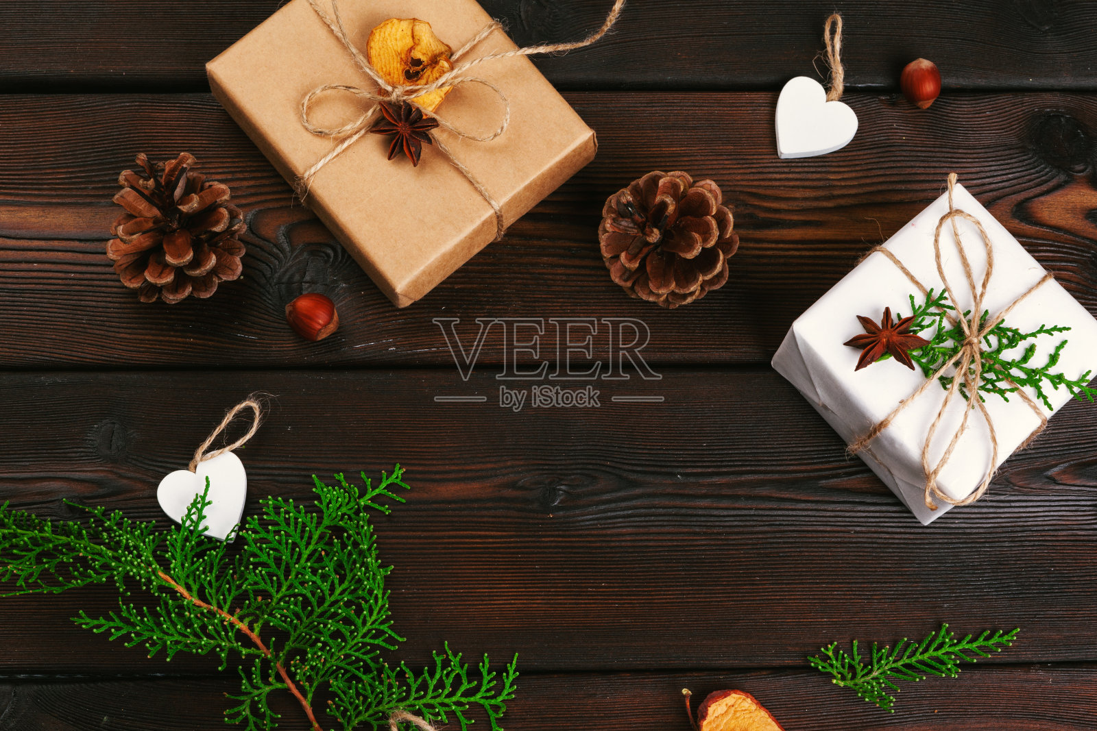 圣诞组成。圣诞礼物，针织毯子，松果，冷杉树枝在木制背景。照片摄影图片