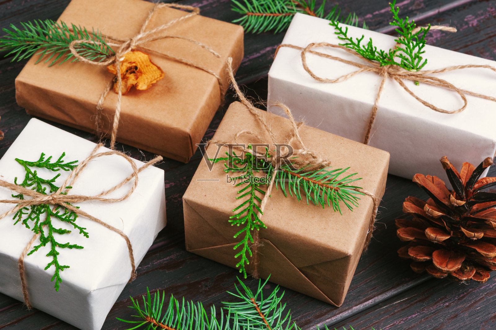 圣诞组成。圣诞礼物，针织毯子，松果，冷杉树枝在木制背景。照片摄影图片